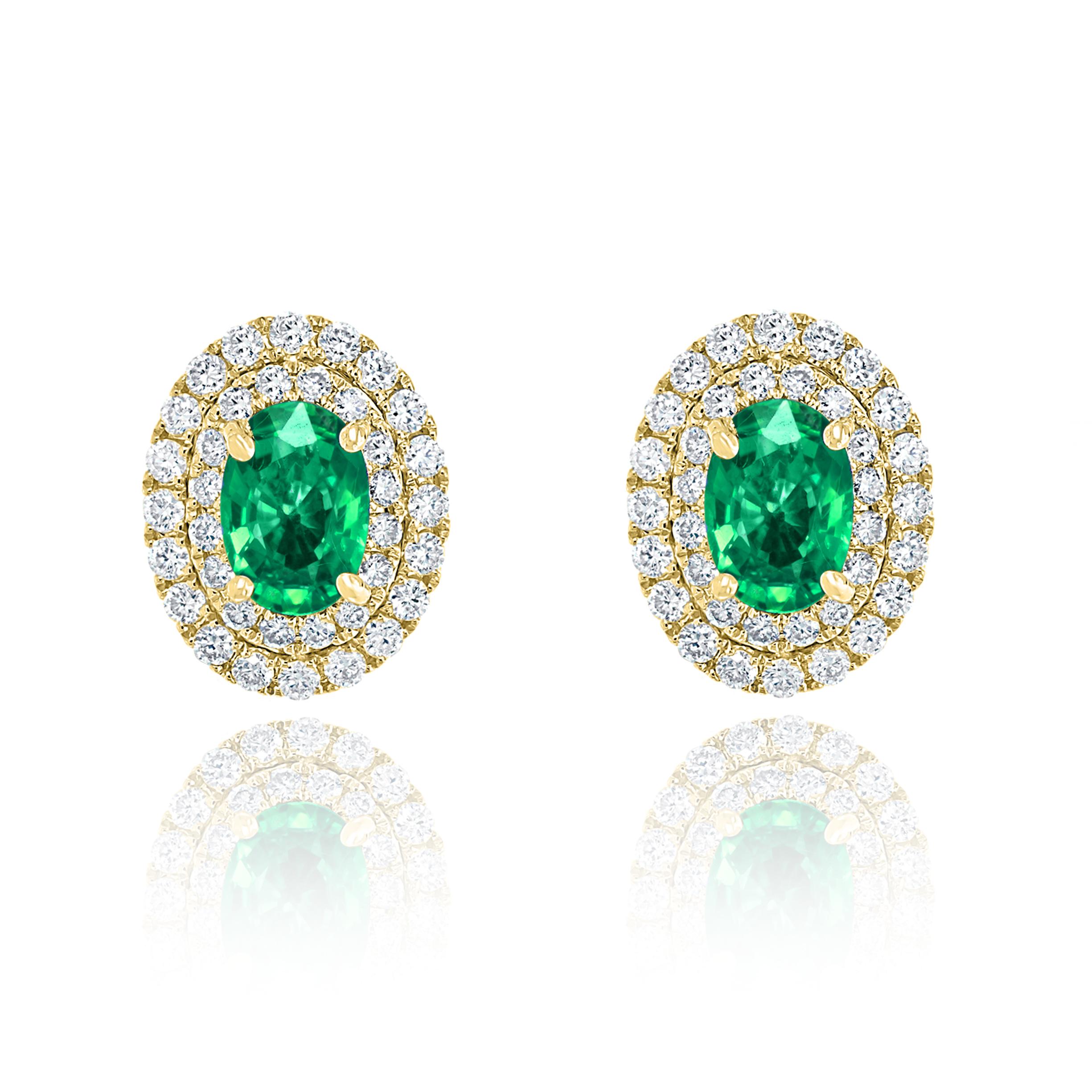 A simple pair of stud earrings showcasing 0.89 carats of oval cut emeralds, surrounded by a double row of 72 brilliant round diamonds weighing 0.48 carats and made in 18-karat yellow gold.