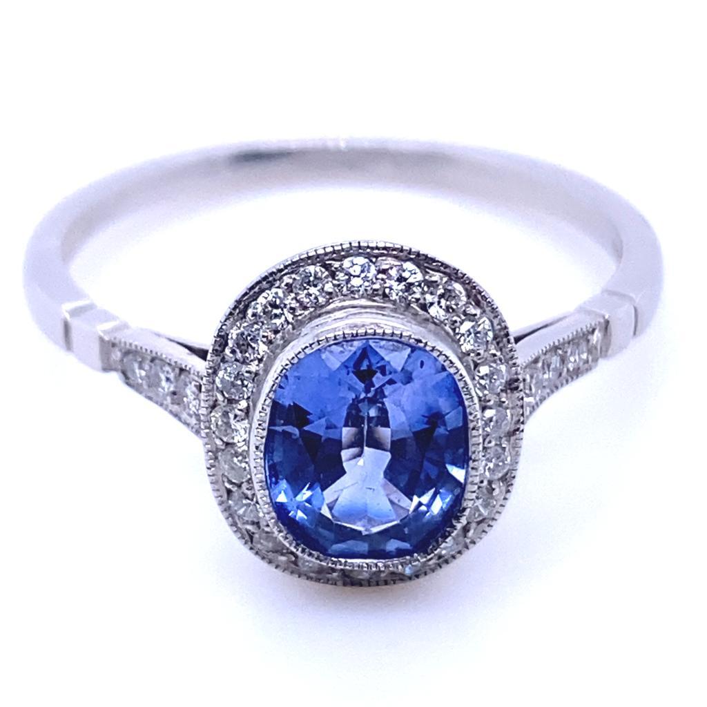 A 0.89 carat sapphire and diamond platinum cluster engagement ring.

This contemporary and classic cluster ring is set with a rich cornflower sapphire oval brilliant cut centre and round brilliant cut diamond surrounds leading to further half