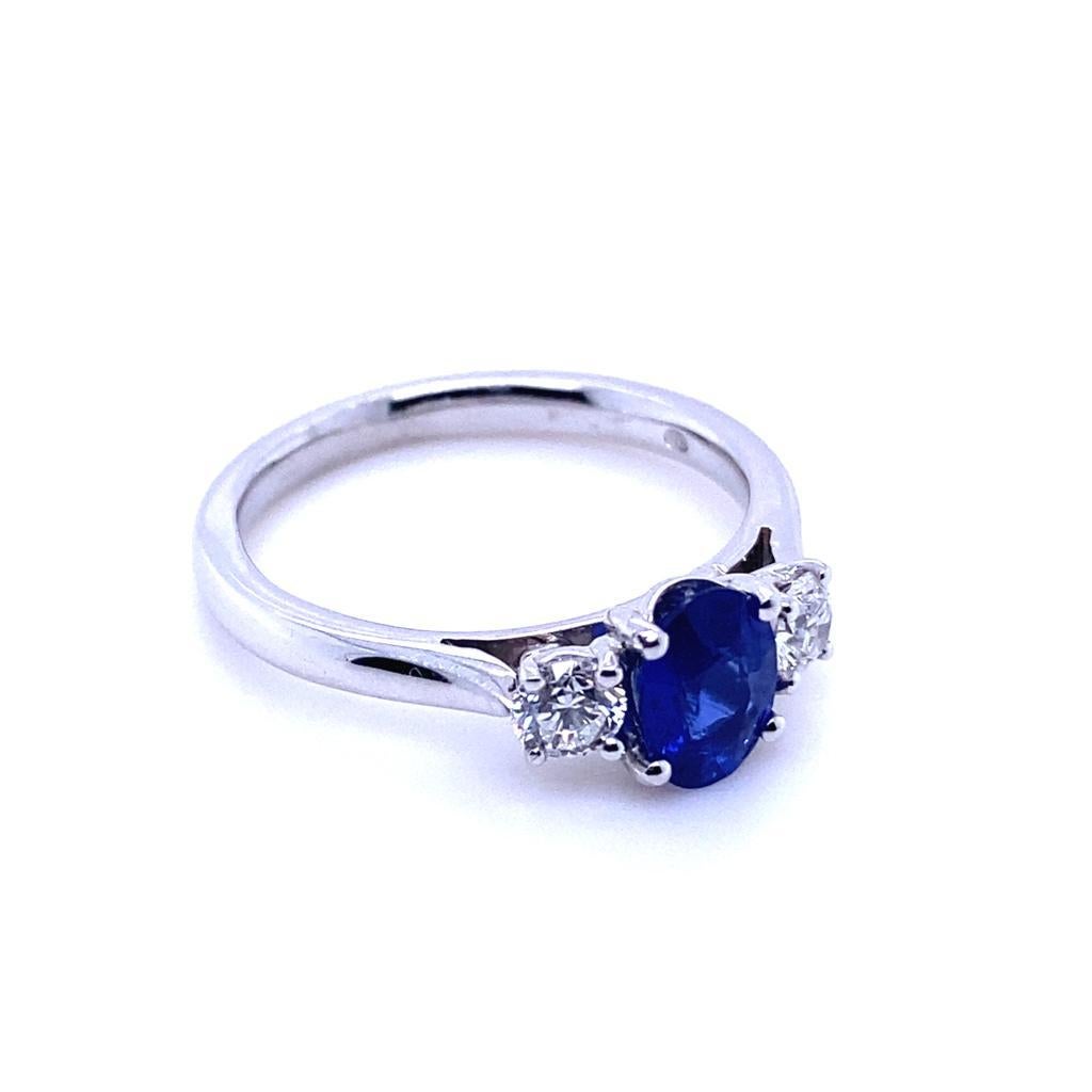 A 0.89 carat sapphire and diamond three stone platinum engagement ring.

This beautiful sapphire and diamond engagement ring is crafted in platinum.  
Claw set to its centre with a oval cut sapphire of 0.89 carats. The stone is a vivid royal blue.
