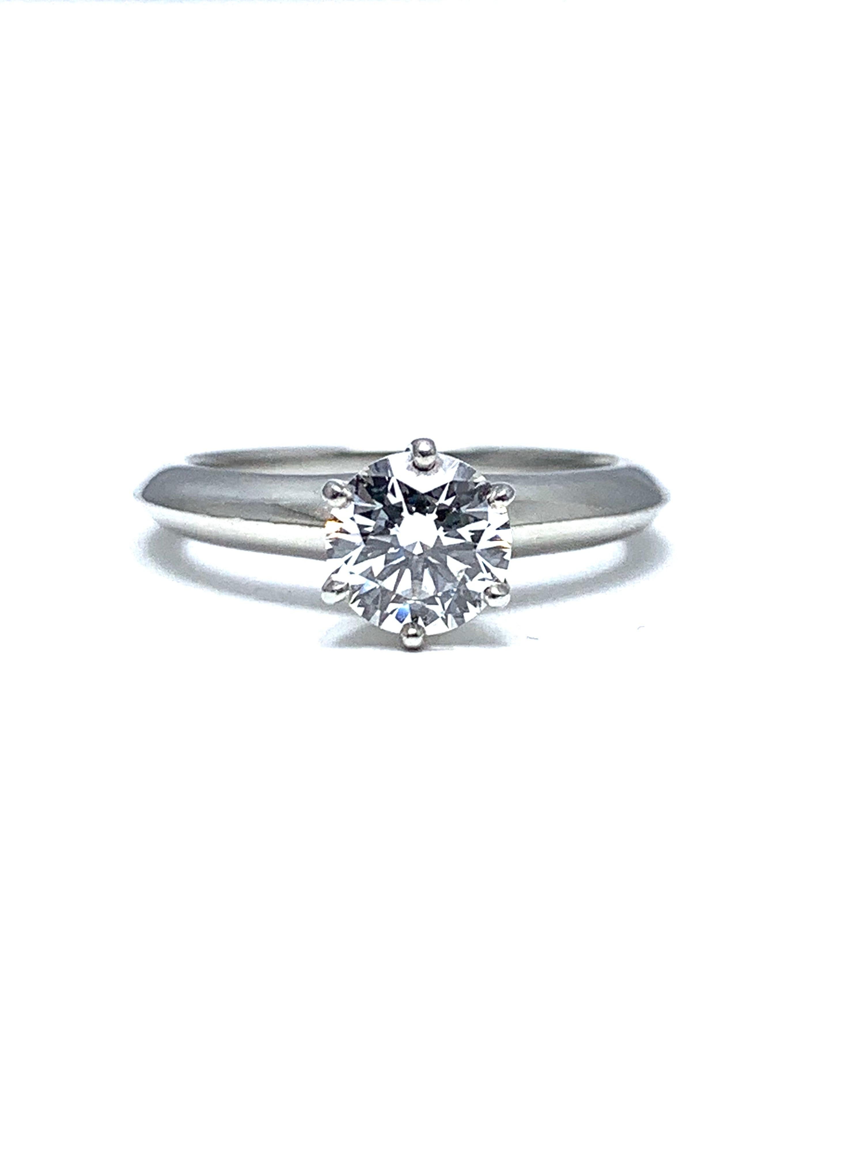 Magnifique bague en platine de Tiffany & Co. avec solitaire en diamant rond et brillant.  Le diamant est serti dans une tête à six griffes sur une tige en lame de couteau.  Le diamant est de 0,89 ct, de couleur E et de pureté VS1.  

Signature : 