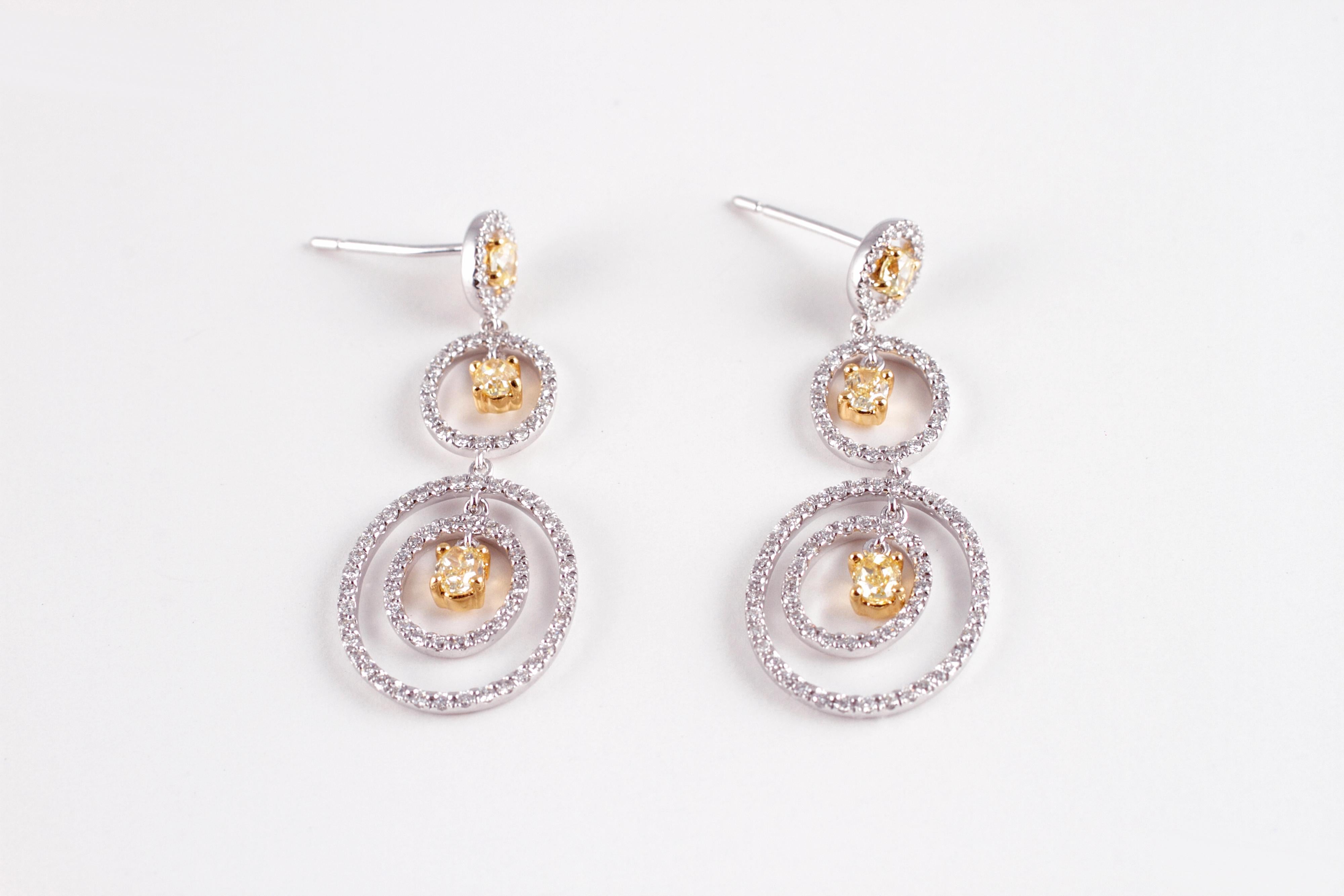Purchased from famed jewelry designer David Morris of London, these earrings support 0.89 carats of beautifully matched yellow diamonds and 0.77 carats of white diamonds and each one is secured with a standard friction back.  The current Retail