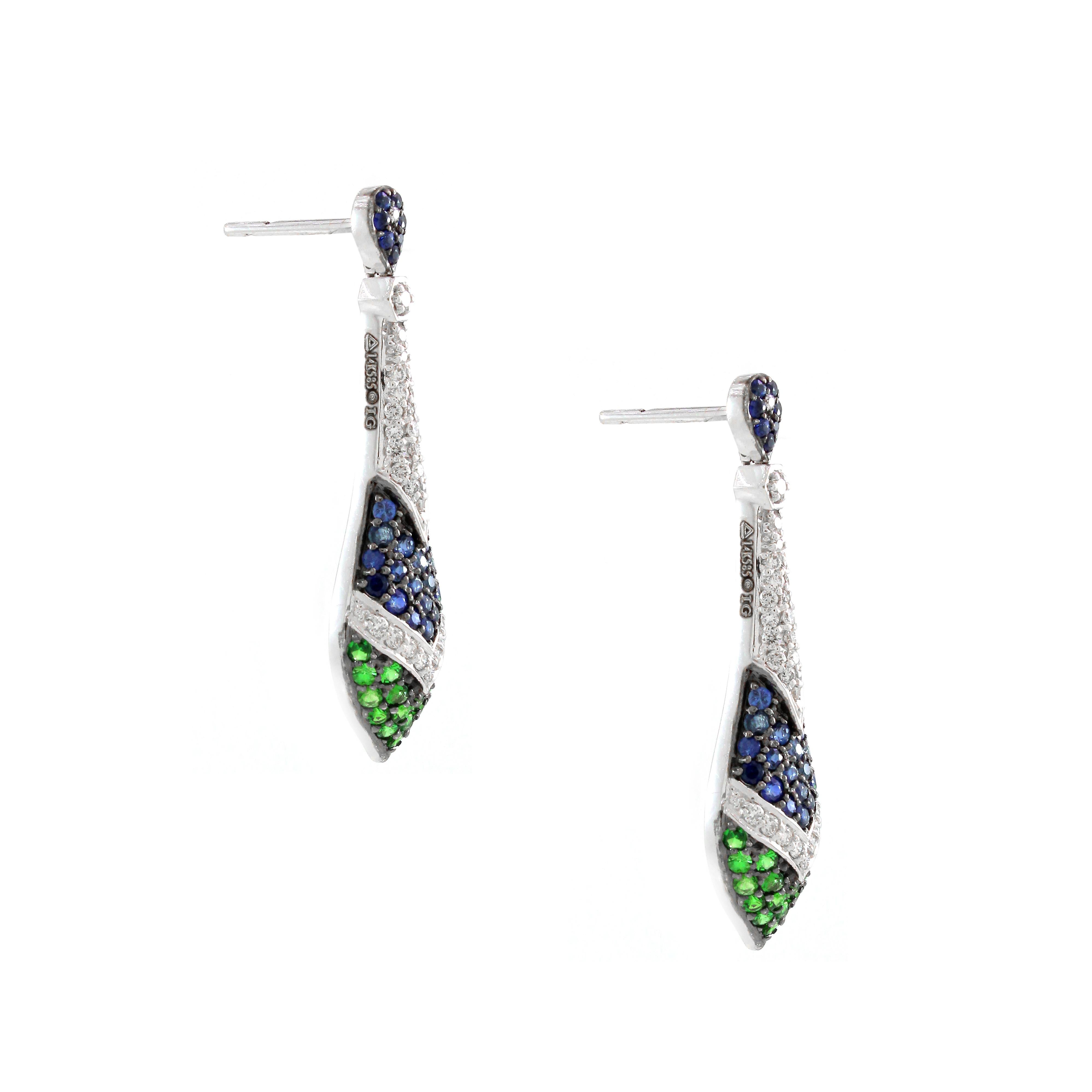 Voici une exquise paire d'Eleg qui marie à merveille l'élégance et les couleurs vives. Chaque boucle d'oreille présente une combinaison éblouissante de pierres précieuses : 0,45 carats de diamants de forme ronde, 0,89 carats de saphirs bleus de