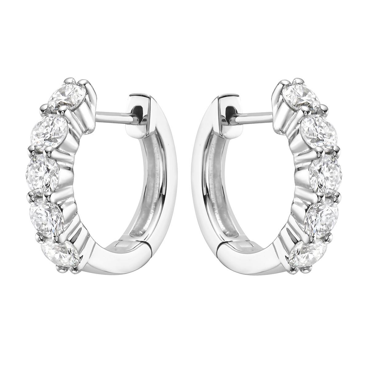 With these exquisite white-gold diamond hoops, style and glamour are in the spotlight. These hoops are set in 18-carat gold, made out of 3.4 grams of gold. The color of the diamonds is G. The clarity is VS2. These earrings are made out of 10