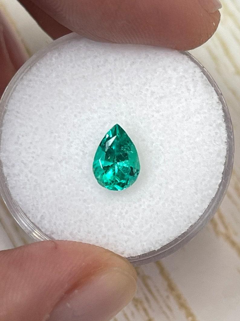 A. Stone: Smeraldo
Peso: 0,90 carati
Forma: Taglio a pera
Chiarezza: Trasparente
Lucentezza: Eccellente
Colore: Verde bluastro vivace
Misure: 7,99 mm x 5,68 mm x 4,31 mm
Origine geografica: Colombia
Trattamento: Naturale, oliatura

Commenti: A causa