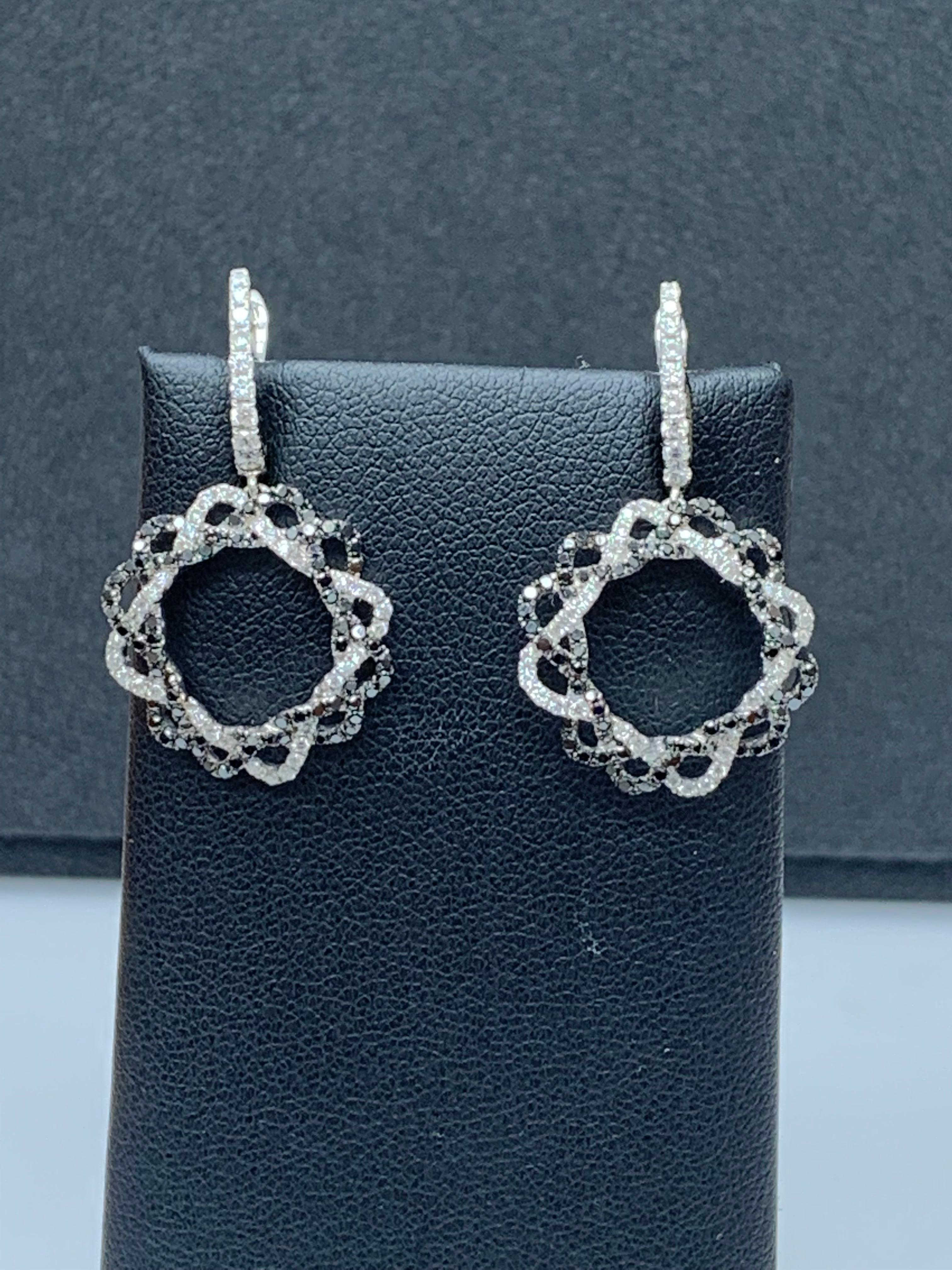 Boucles d'oreilles pendantes présentant un design ajouré, avec des diamants noirs ronds de fantaisie pesant 0,90 carats et des diamants blancs taille brillant pesant 0,62 carats au total.Making Works in 18 carat white gold.