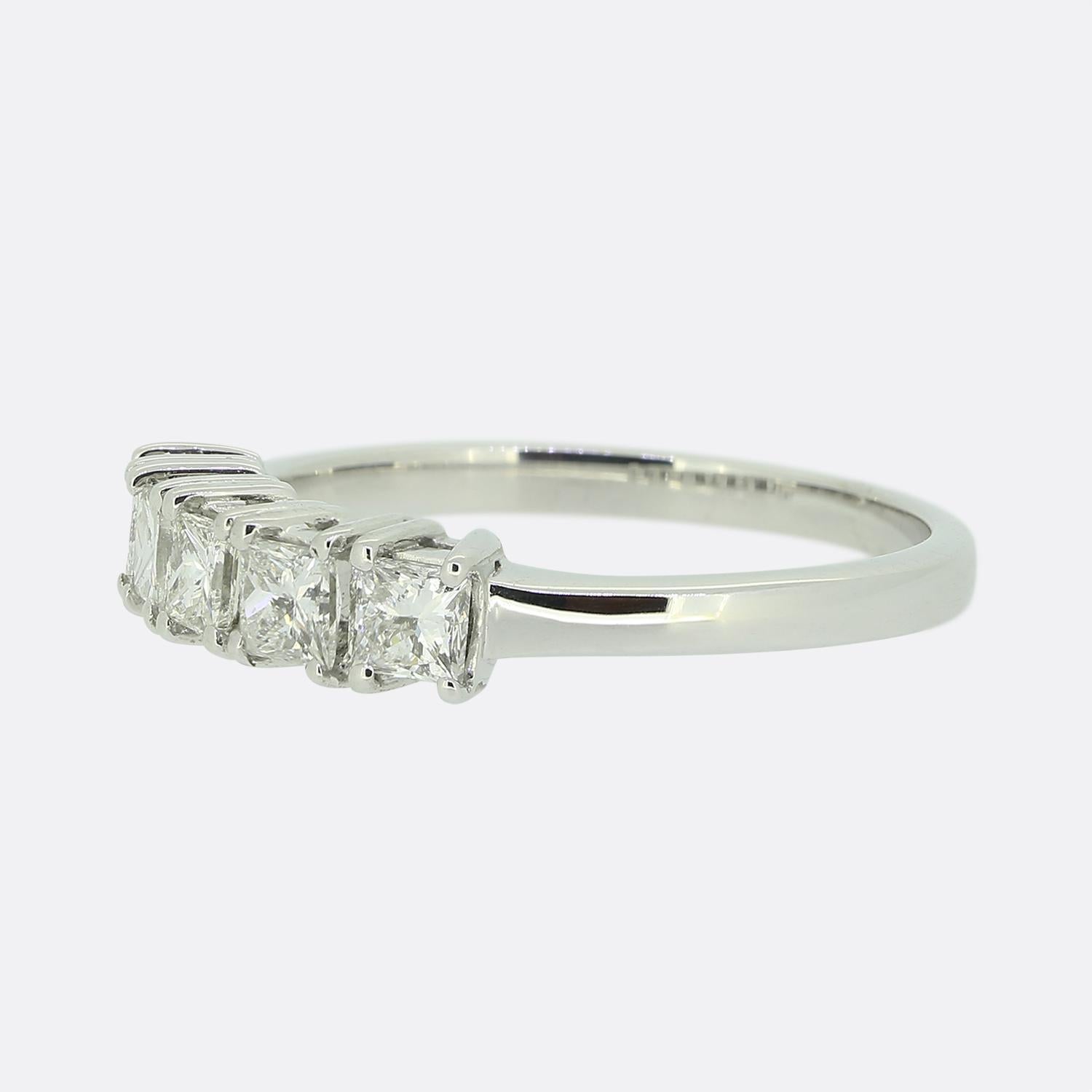 Ecco un elegante e raffinato anello con cinque pietre e diamanti. Questo pezzo in oro bianco 18 ct ospita cinque diamanti taglio princess; tutti sono stati incastonati singolarmente in una formazione collettiva a linea singola e sono