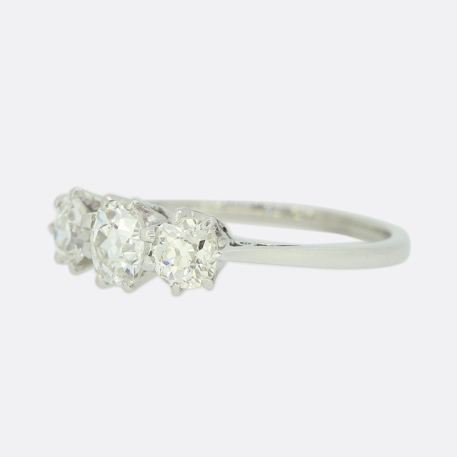 This is a vintage 18ct white gold three-stone ring. The central stone is a 0.40 carat round old cut diamond which is closely flanked on either side by a single slightly smaller old cut diamond. Each stone here is claw set and very well matched for