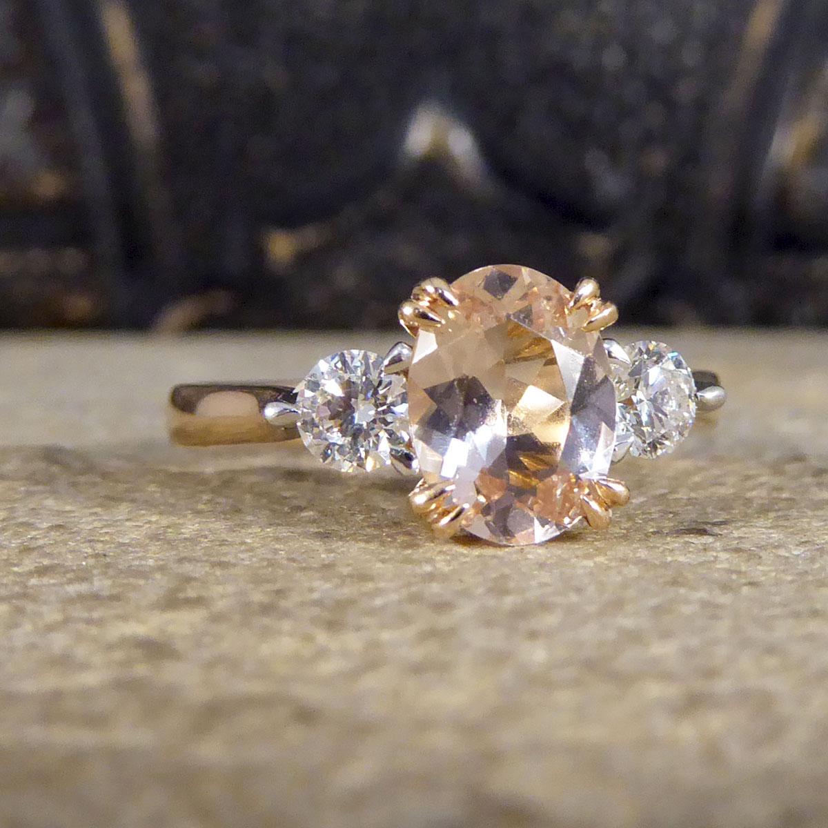 An absolutely gorgeous and sparkly Pink Morganite and Diamond three stone ring that holds three beautiful stones set in a secure four double claw setting. In the centre sits a lovely bright Oval Cut Pink Morganite in the centre weighing 0.90ct with