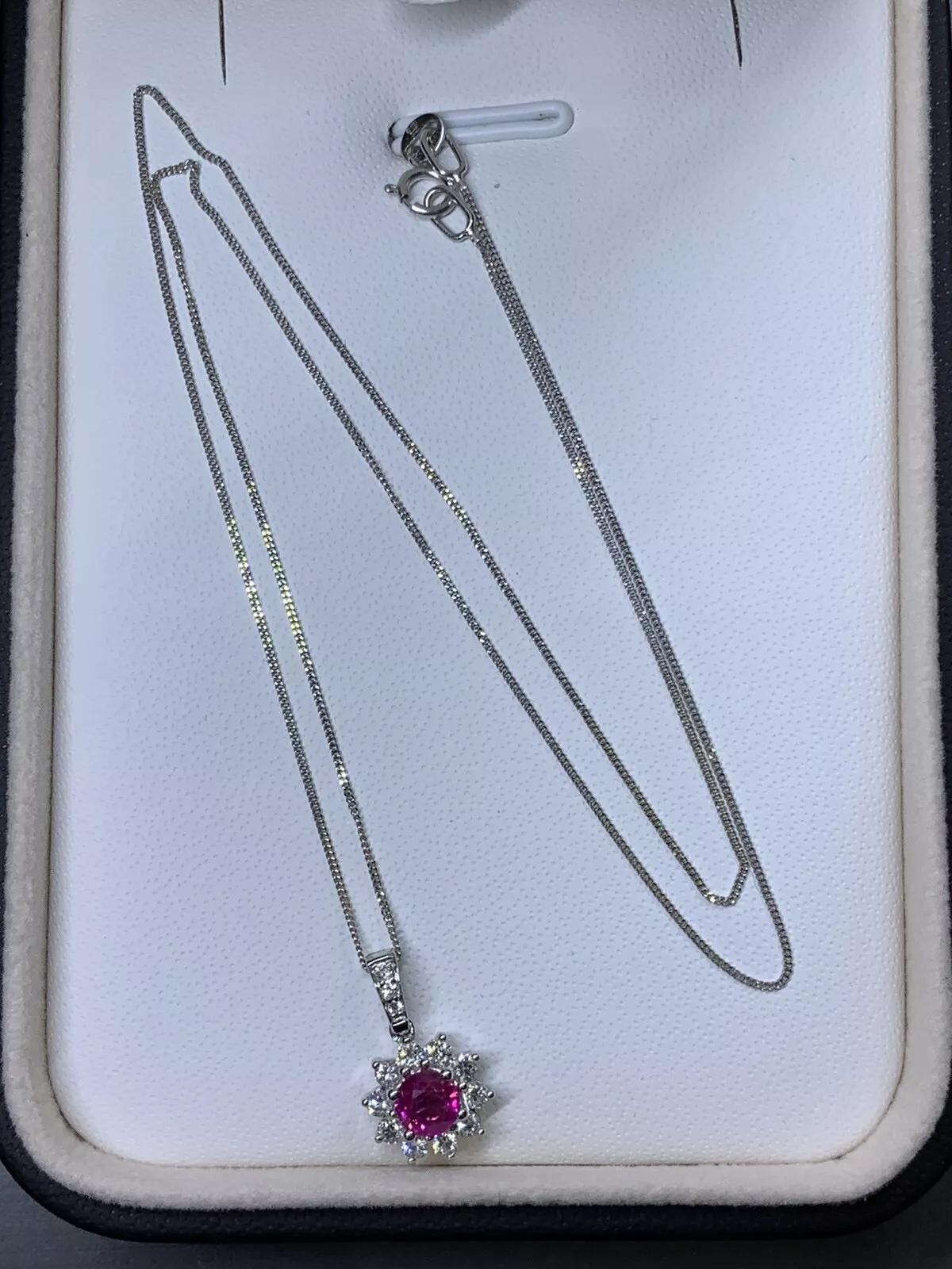0,90ct Rubis et diamants halo cluster pendentif Chaîne en or blanc 18k.

Rubis naturel non chauffé, rond, poids total 0,45ct

Grand collier pédant en rubis et diamants en or blanc 18ct.

Poids total du halo de diamants 0,45ct Couleur G VS1