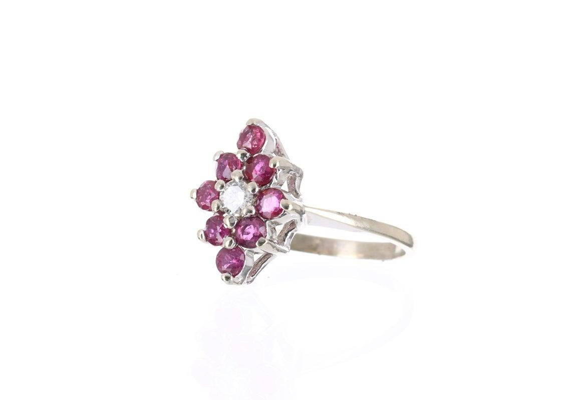 Elegantly displayed is a vintage ruby and diamond ring. Expertly handcrafted in gleaming 14K white gold; this ring features numerous natural rubies that follow the length of the finger. These beautiful rubies are the color fuchsia and have excellent