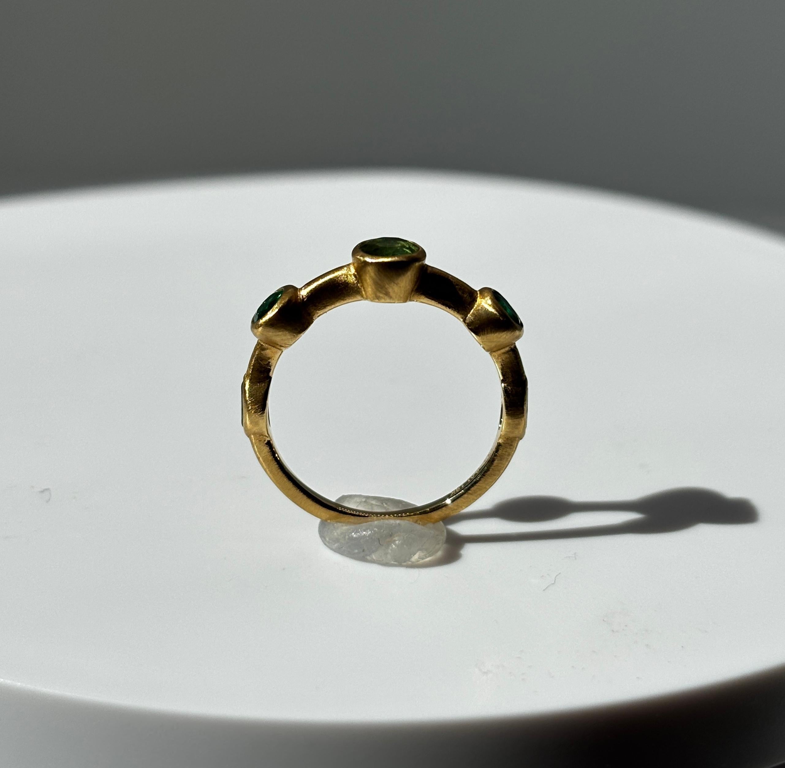 USA 6.5 Misura dell'anello
Smeraldi colombiani 0,91 carati / 5 pezzi 
Oro giallo 18 carati

Scopri l'eleganza contemporanea con questo straordinario anello a fascia in oro spazzolato, con una selezione curata di smeraldi colombiani di prima qualità