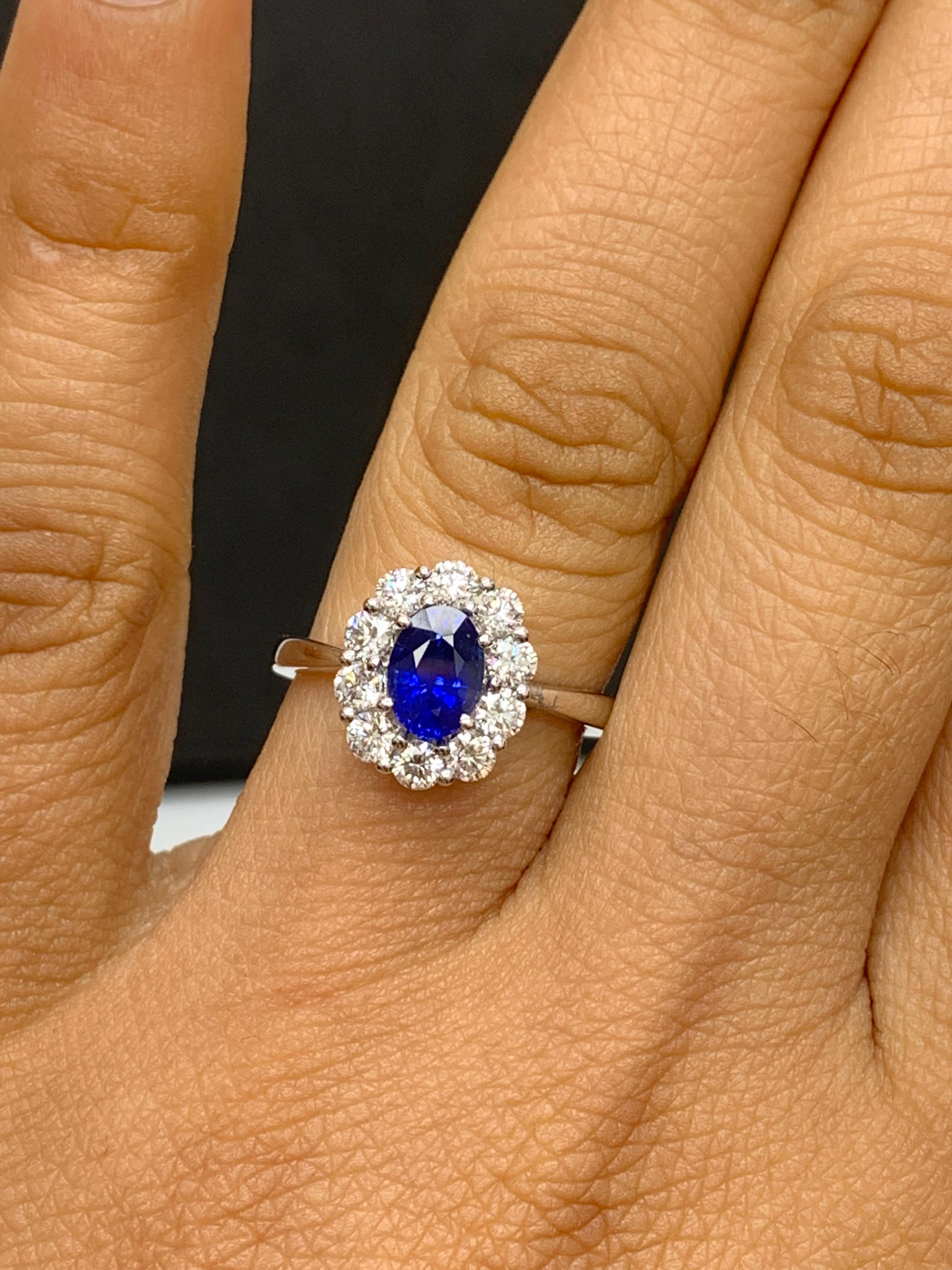 A stunning well-crafted engagement ring showcasing a 0.91-carat oval cut Blue Sapphire. Flanking the center diamond are perfectly matched brilliant cut 10 diamonds weighing 0.74 carats in total, set in a polished 18K White Gold mounting. Handcrafted