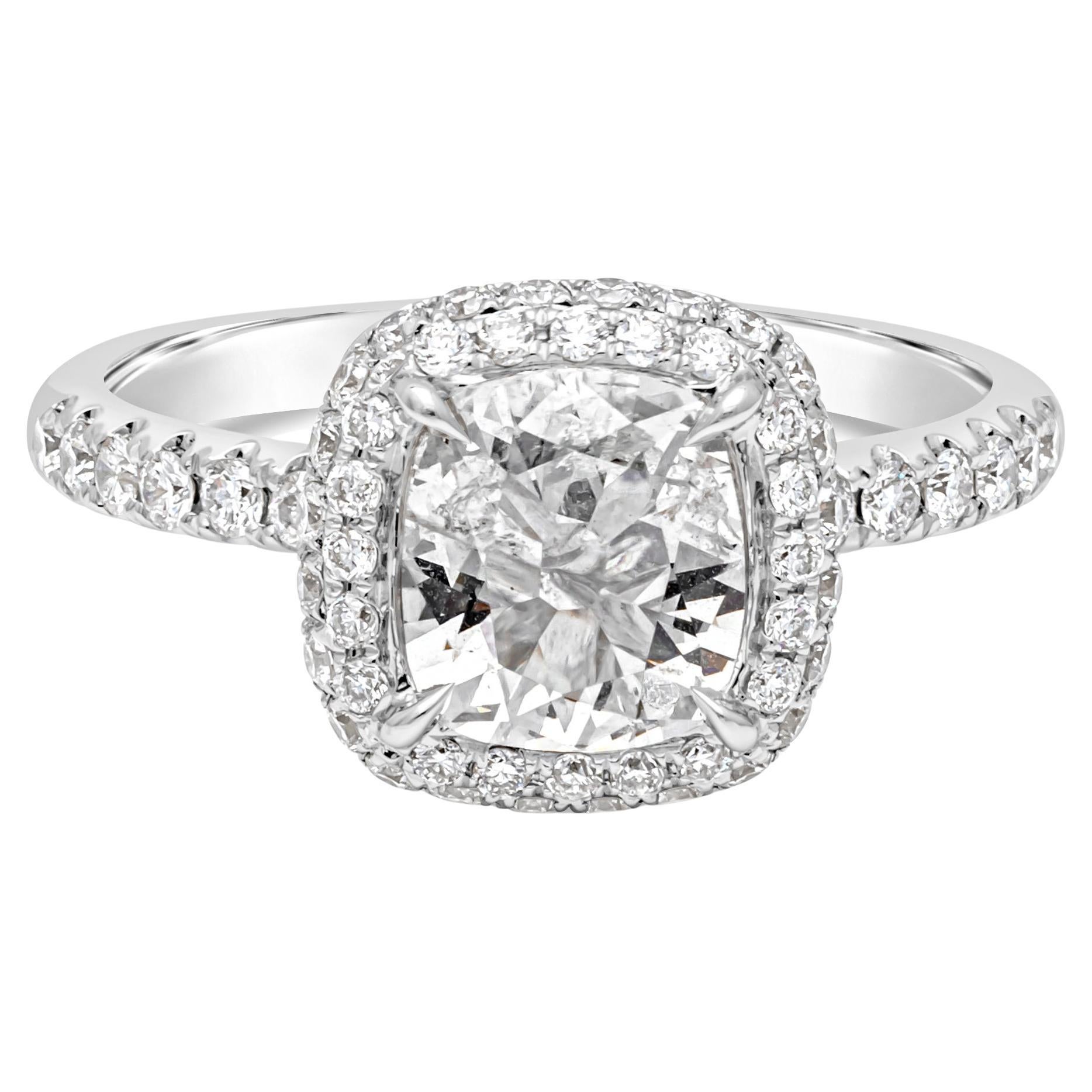 Brilliant and elegantly made halo engagement ring showcasing a EGL certified 0.91 carats cushion cut diamond, F Color and SI2 in Clarity. Set in a four prong setting and surrounded by a row of brilliant round diamonds. Set in a half eternity pave