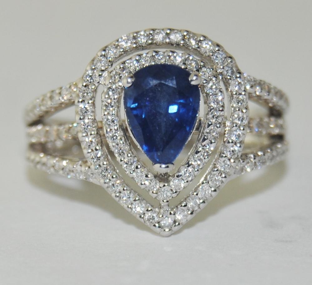 Ladies 0.92 Carat Pear Shape Blue Sapphire Center Ring surrounded by 0.47 Carat Brilliant Round White Diamonds.  This new ring is made of 14 Karat White Gold.  Size 4.75