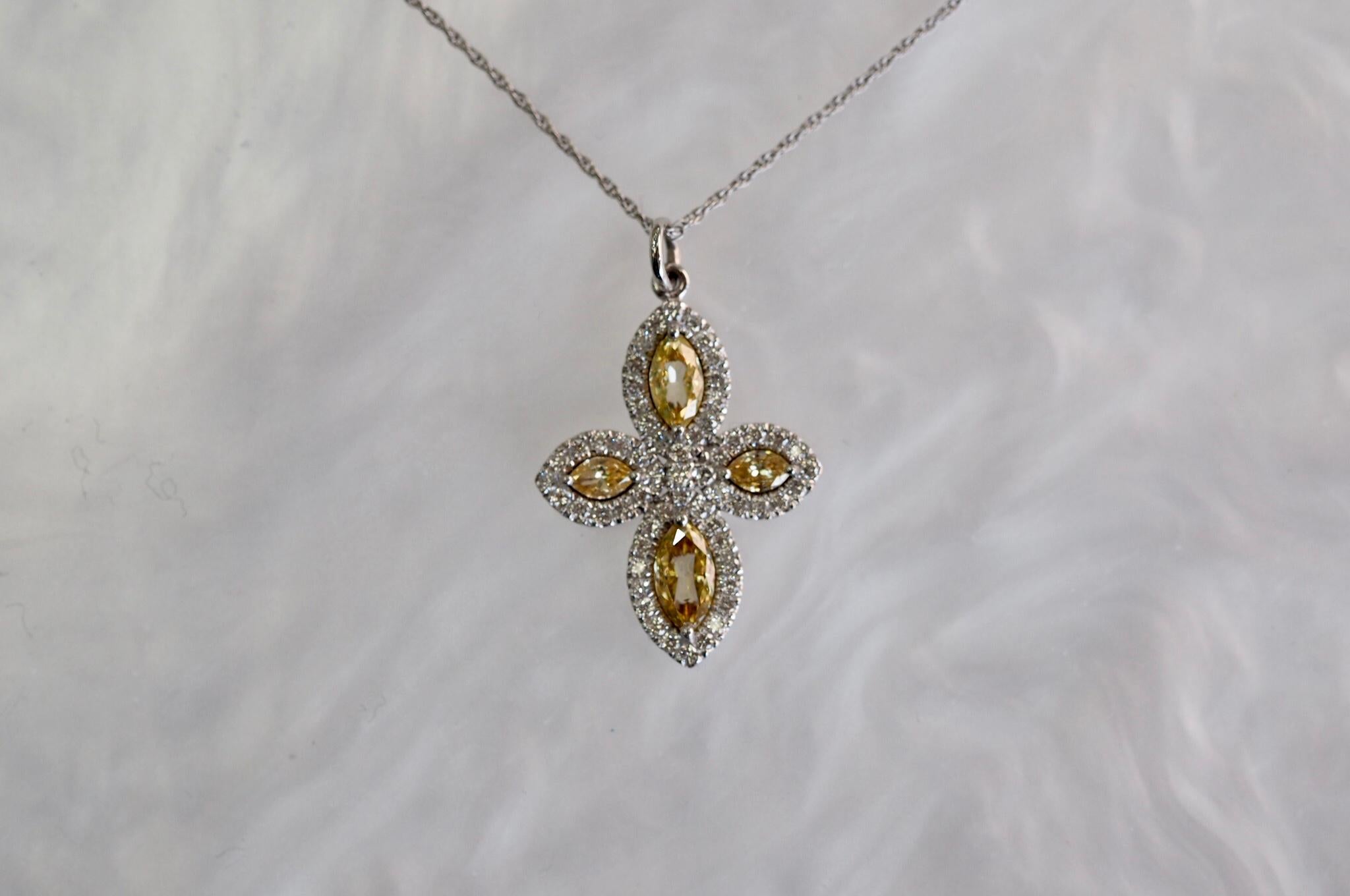 This Diamond Cross Necklace includes four yellow marquise shape diamonds weighing 0.55 carats and 0.37 carats of white round brilliant cut diamonds. It is 0.92 carat total weight in diamonds. It is set in 14 karat white gold including the 16'' cable