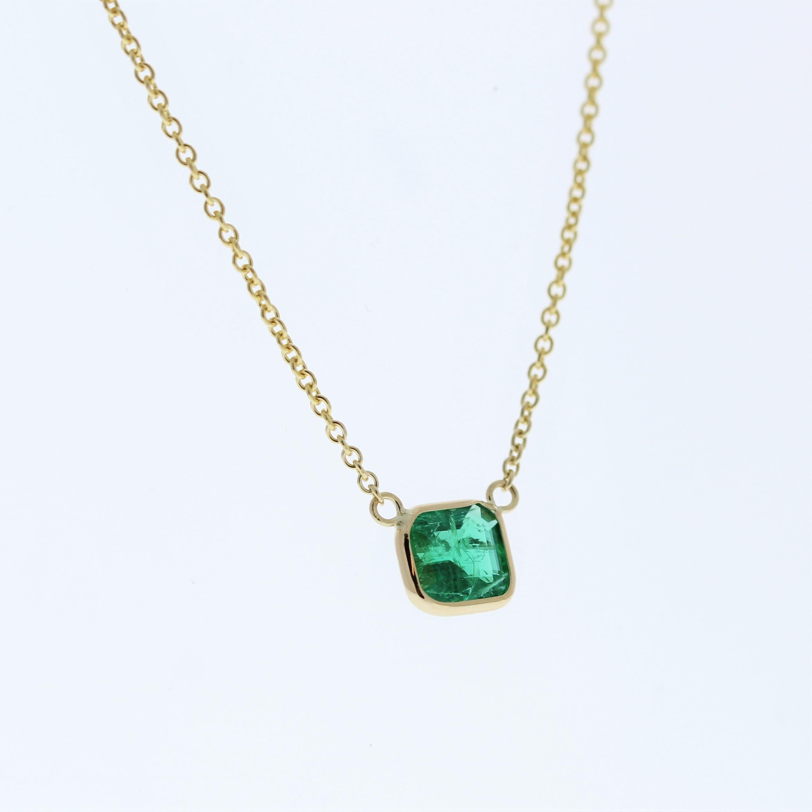 The necklace features a 0.94-carat Asscher-cut green emerald set in a 14 karat yellow gold pendant or setting. The Asscher cut and the vibrant green color of the emerald against the yellow gold setting are likely to create an elegant and