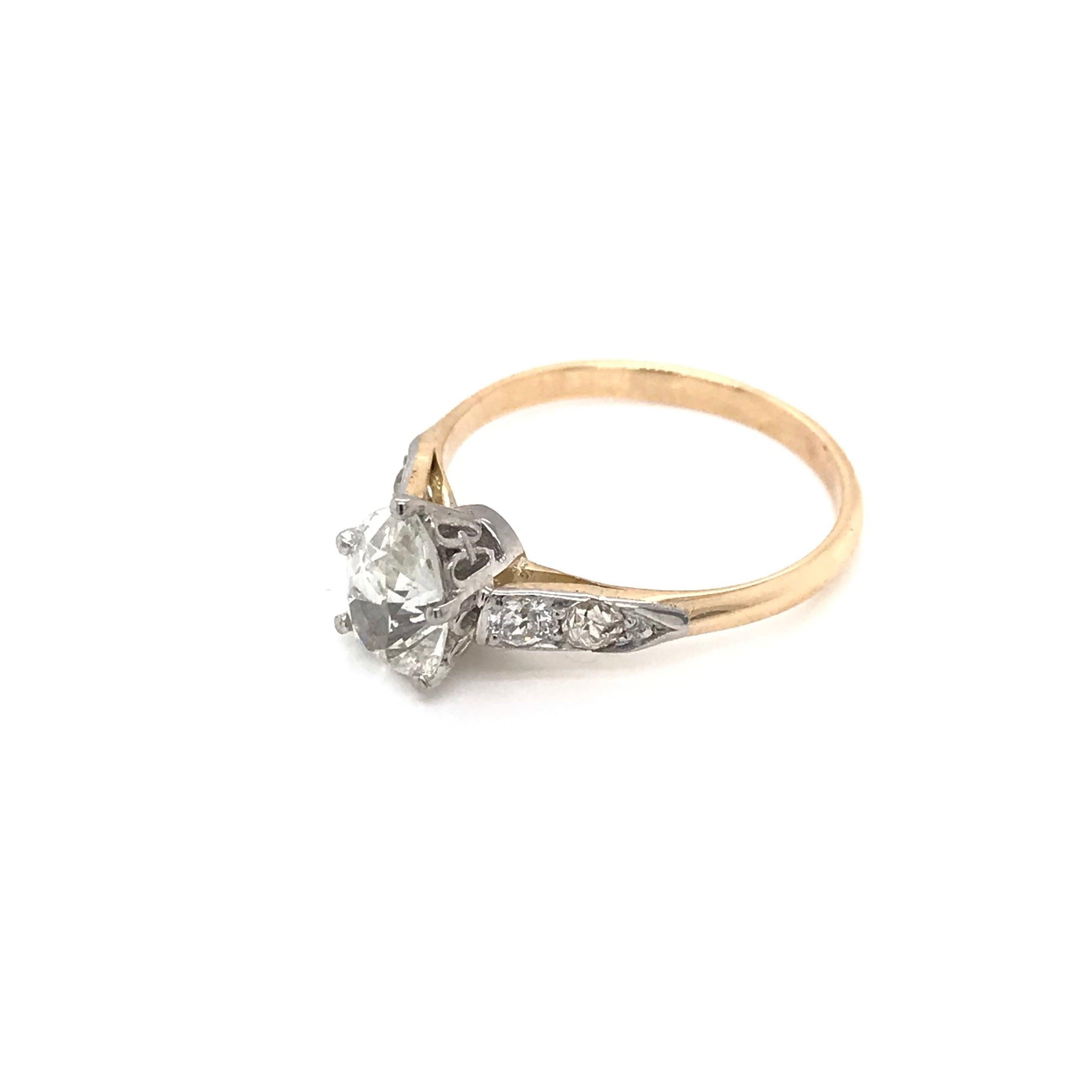 This solitaire style diamond ring is an estate piece. The ring features a center pear cut diamond measuring approximately 0.95 carats and grading J in color, SI1 in clarity. The setting is 14k yellow gold with 14k white gold accents. The setting