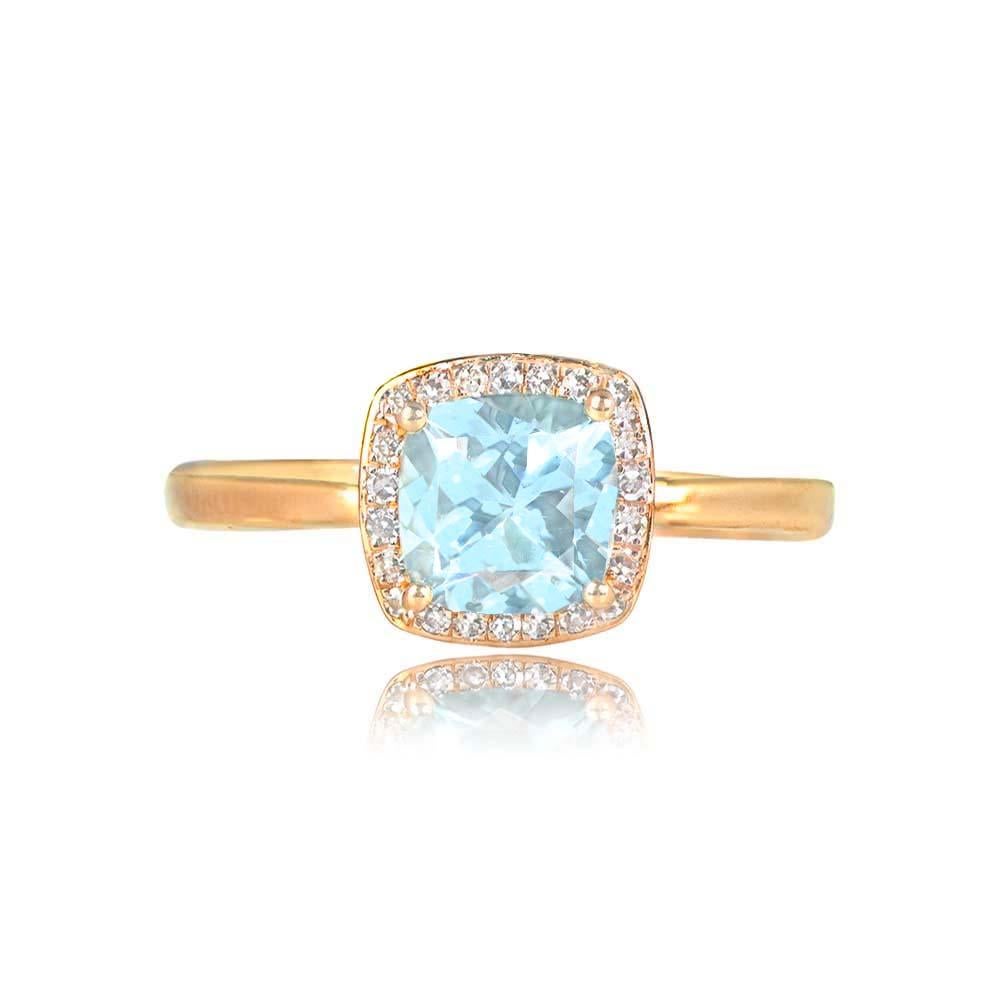 This elegant engagement ring features a 0.95-carat cushion-cut aquamarine set with prongs. It is encircled by a halo of single-cut diamonds, with a total diamond weight of approximately 0.15 carats. The ring is meticulously handcrafted in 18k yellow