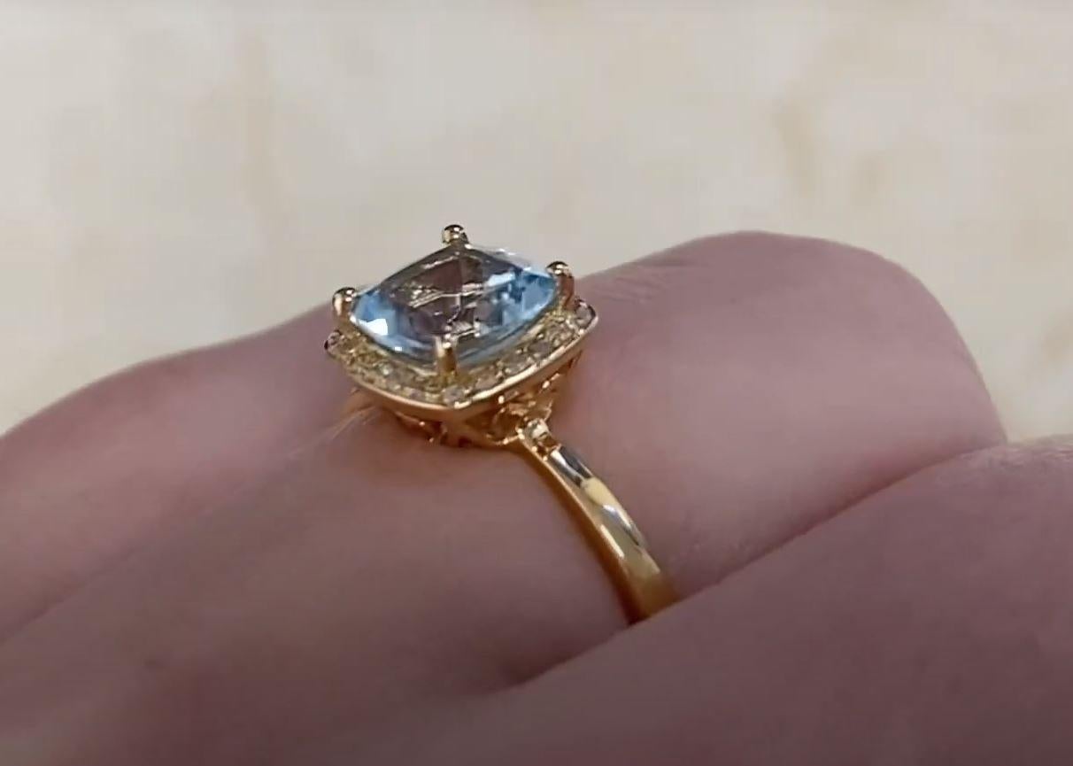 This exquisite engagement ring features a captivating approx 0.90-carat cushion-cut aquamarine, its serene blue hue beautifully enhanced by a delicate prong setting. The aquamarine’s soft, ethereal glow is framed by a shimmering halo of single-cut