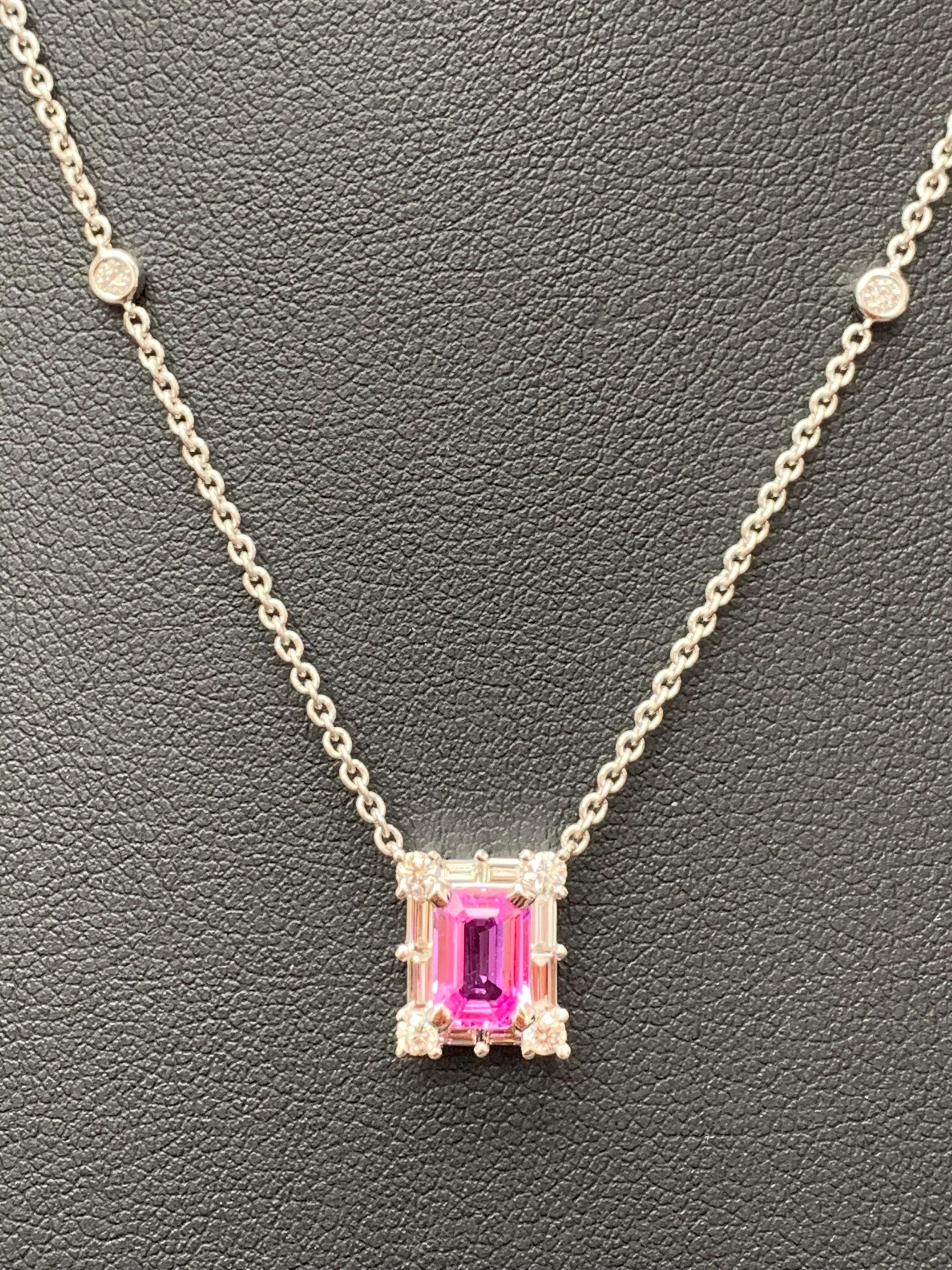 A fashionable pendant necklace showcasing a 0.96-carat emerald cut vibrant pink color Sapphire. The center stone is surrounded by a row of brilliant-cut 8 round and 8 baguette diamonds weighing 0.58 carats total. Made in 18k white gold. Comes with a