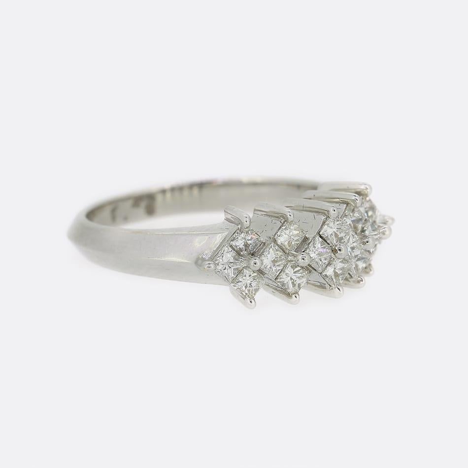 Dies ist ein Diamantring aus 18 Karat Weißgold. Der Ring ist mit einer Reihe von Diamanten im Prinzess-Schliff besetzt, die in der Höhe zu den zentralen 4 Diamanten hin abnehmen. Die Diamanten sind in Farbe und Reinheit gut aufeinander abgestimmt