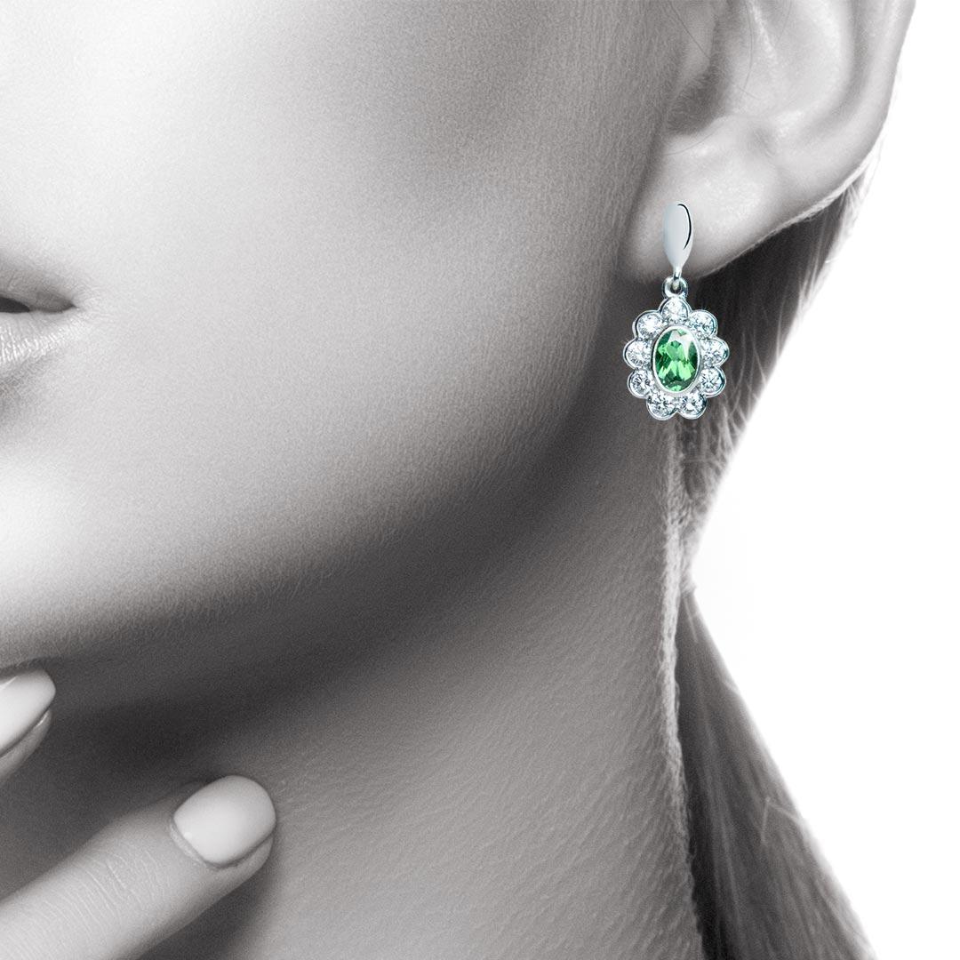 A gorgeous pair of oval bright green tourmalines are offset by a flower-shaped cluster of sparkling diamonds. A striking pair of earrings which can be worn for work and pleasure. The Tourmalines weigh a total of 0.96 carat and the total diamond