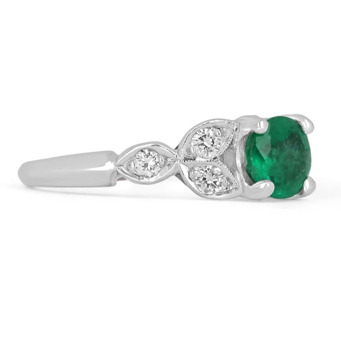 A unique emerald and diamond ring. The center stone features an 0.96-carat round cut Colombian emerald. The emerald displays beautiful bluish-green color and good eye clarity. The stone is accented by brilliant round diamonds going down the shank in