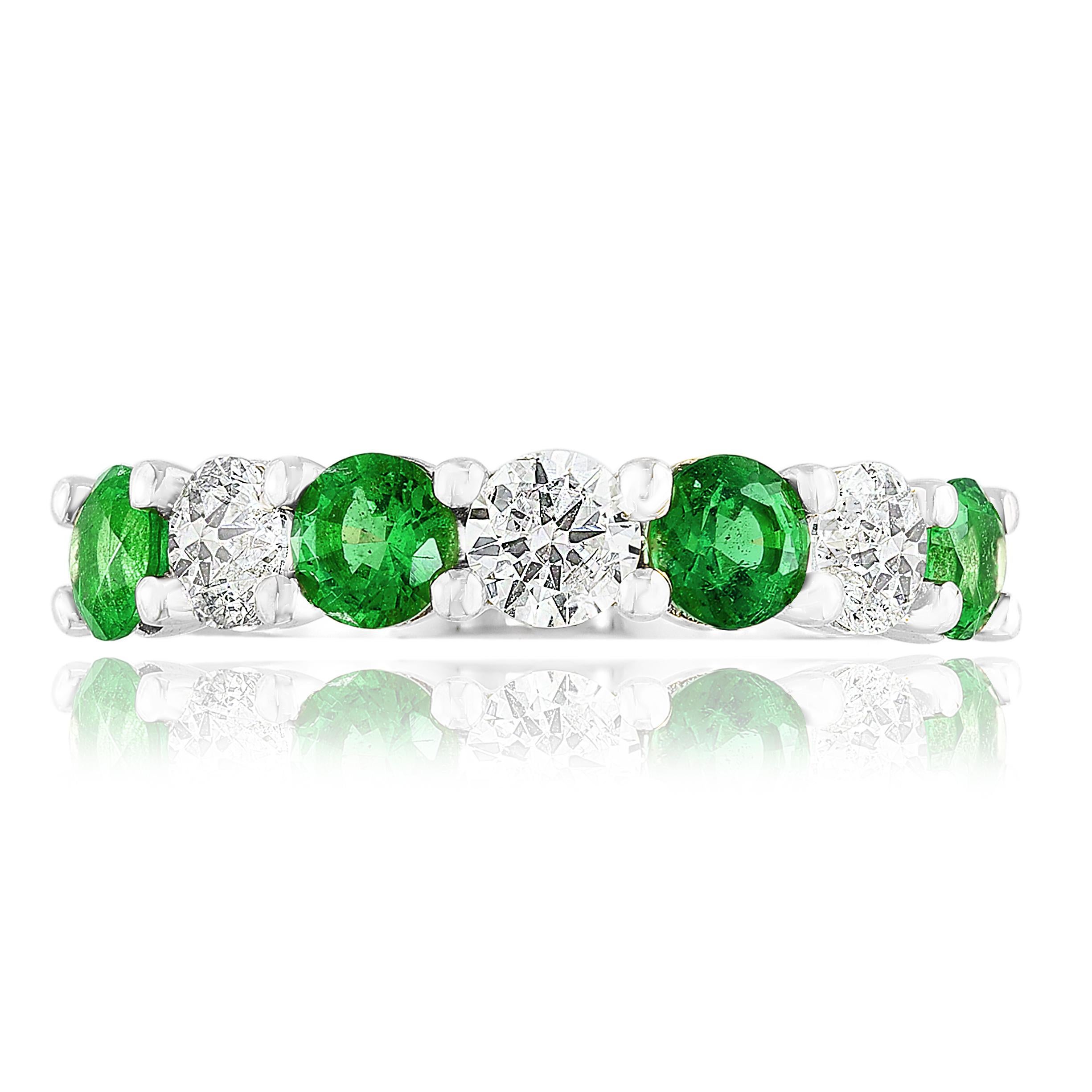 A fashionable and classic wedding band showcasing 4 color-rich green emeralds weighing 0.97 carats total that alternate with 3 brilliant round diamonds weighing 0.73 carats total. Stones secured with a shared prong setting made with 14 karats white