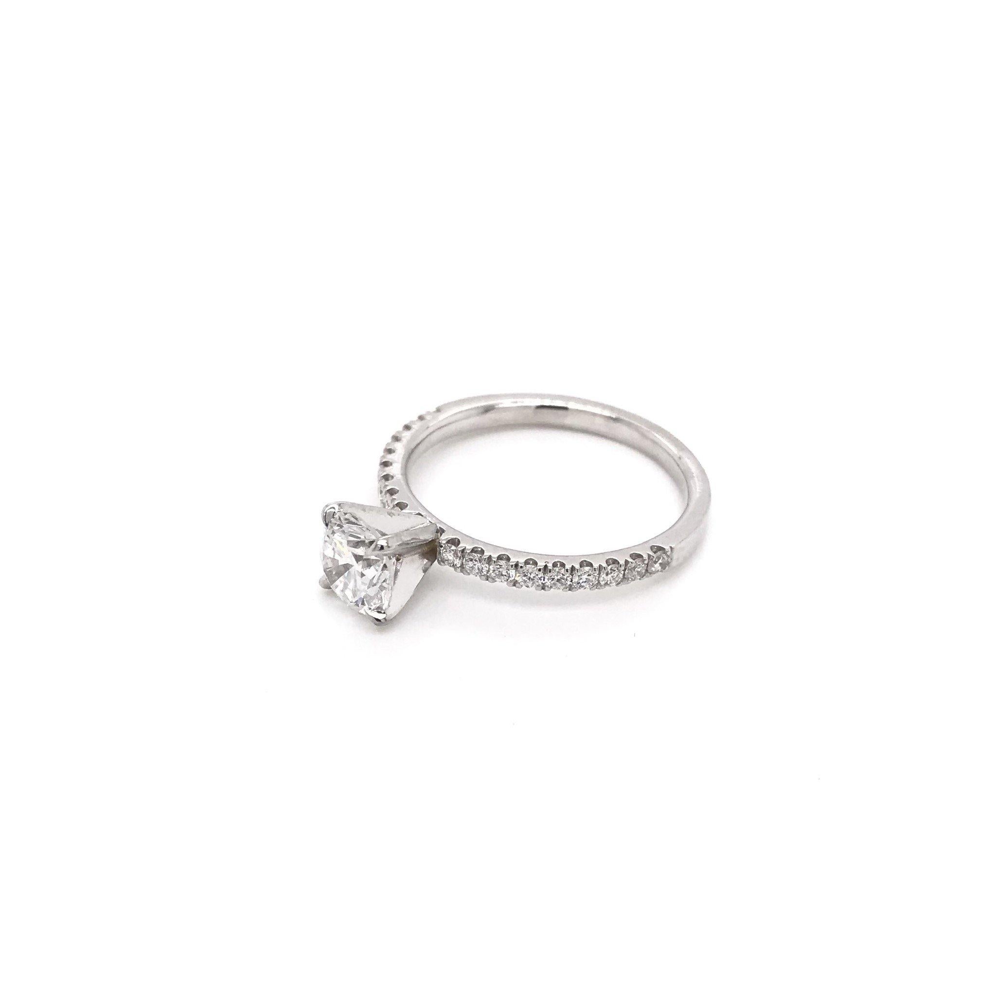 A contemporary style, this diamond ring is new. The 14k white gold setting features a beautiful 0.97 carat round diamond. The diamond grades approximately F in color, VS2 in clarity. This diamond has been certified by the Gemological Institute of