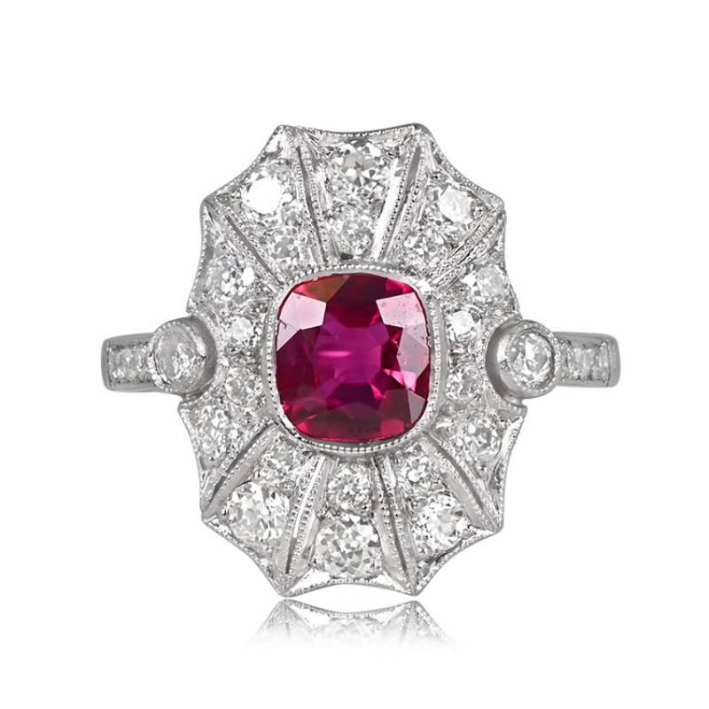 A platinum ring showcasing a bezel-set 0.97-carat cushion cut natural Burma ruby, encircled by pave-set diamonds. Two accent diamonds in bezel settings and pave-set shoulders enhance the allure of the center stone. Geometric cutouts and fine
