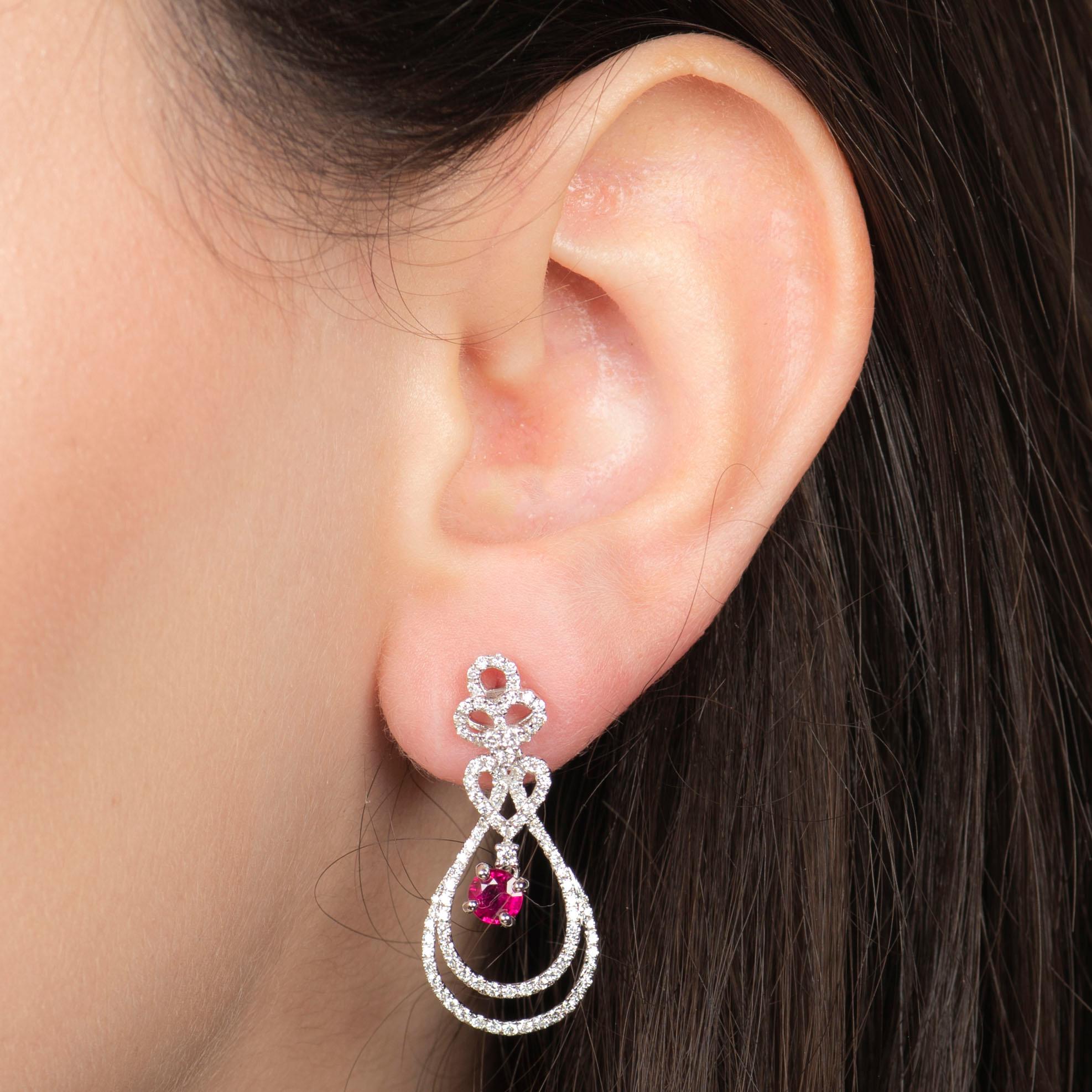These intricate diamond and ruby dangle earrings have a 0.97ct total weight in natural round brilliant cut diamonds and a 0.74ct total weight in round natural rubies, which have a little pink-ish hue. The stones are encased in 18kt white gold. These