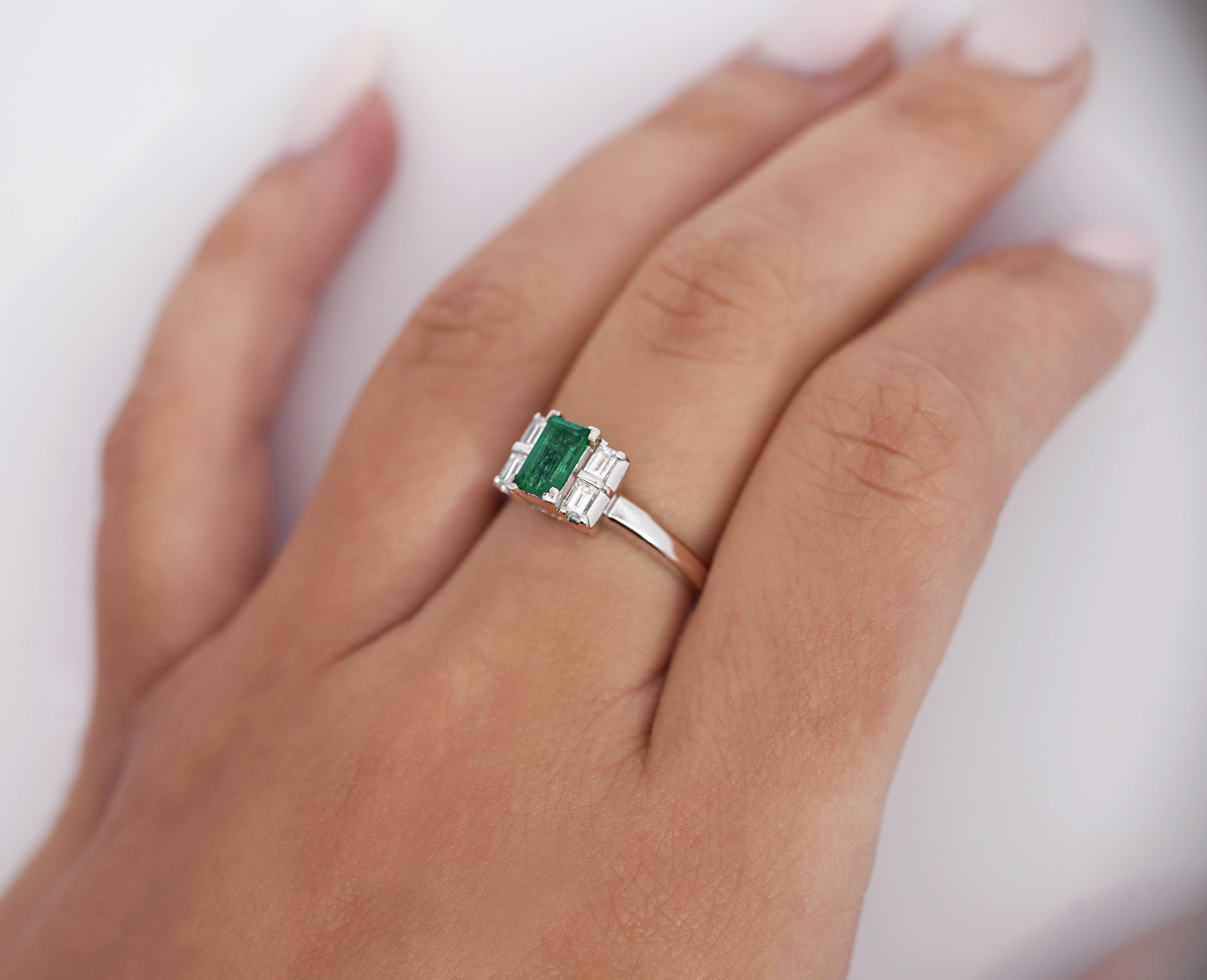 Colombian Emerald and Diamond 5 Stone Platinum Ring. 

This dainty ring is crafted from platinum 900. It features a Colombian emerald center stone, weighing 0.64 carats, with an elongated shape. Secured in prong setting and has an excellent color.