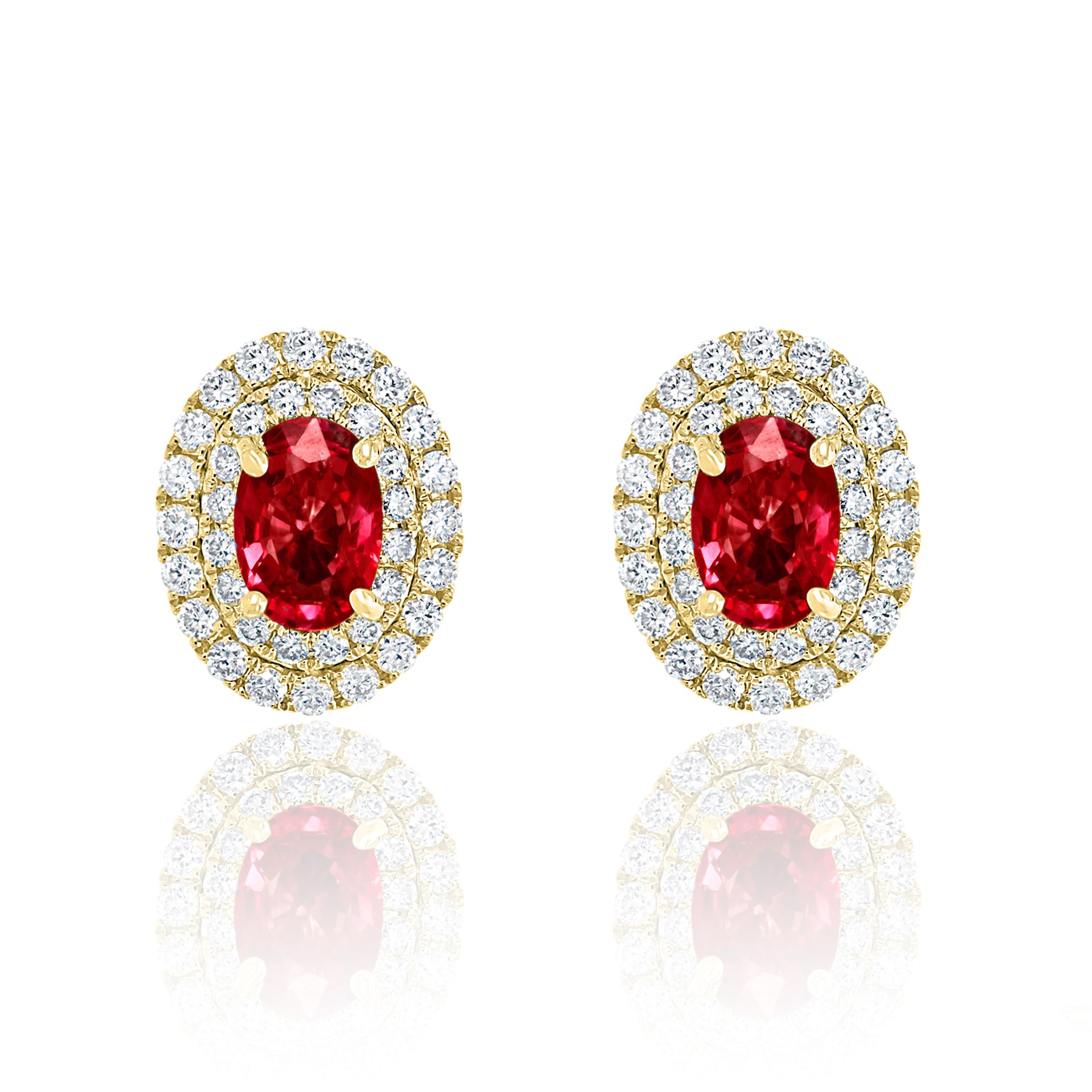 A simple pair of stud earrings showcasing 0.98 carats of oval cut 2 red rubies, surrounded by a double row of 72 brilliant round diamonds weighing 0.48 carats and made in 18-karat yellow gold.
