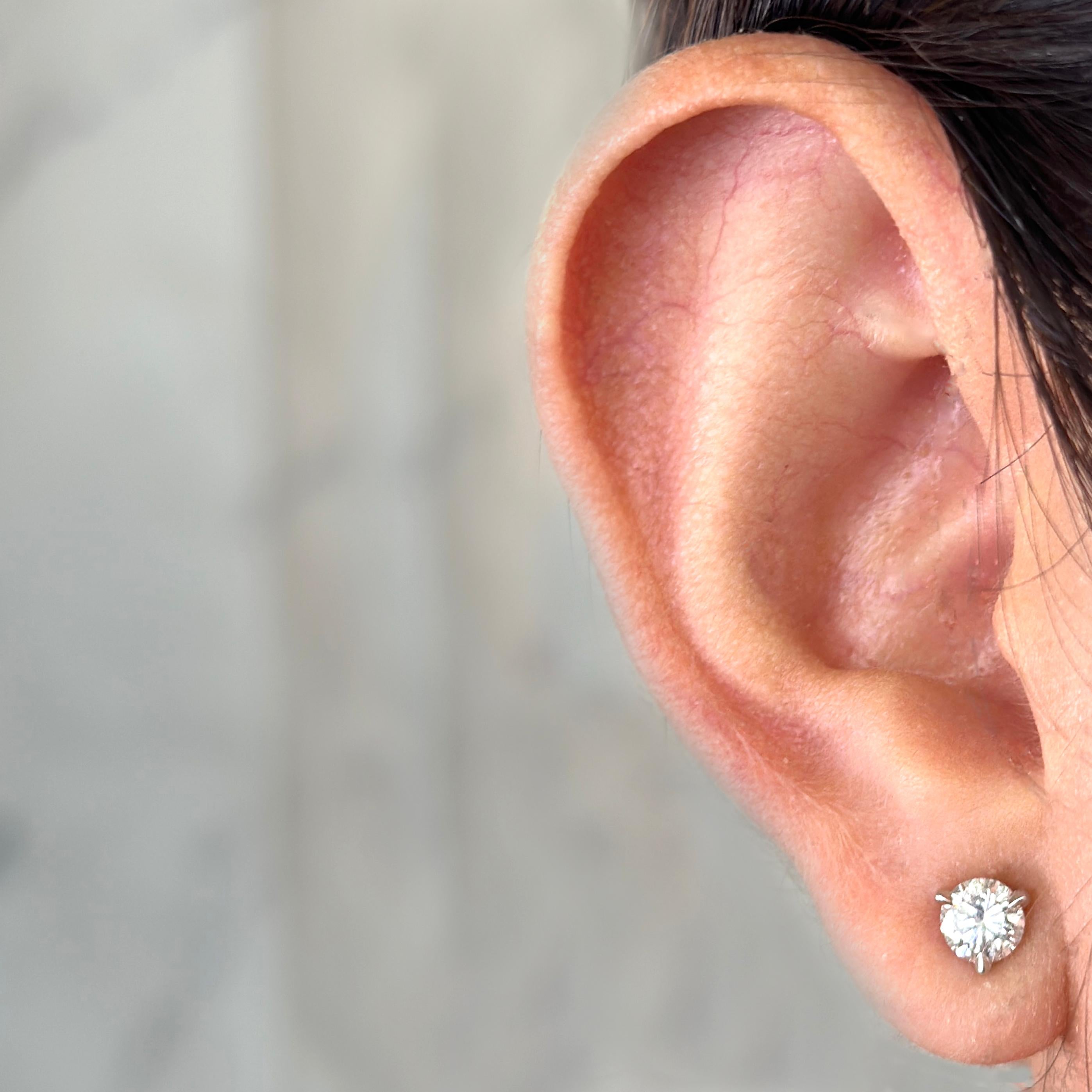 Classic 14 Karat White Gold 3-Prong Diamond Stud Earrings Featuring 2 Round Brilliant Cut Diamonds of G Color and SI2 Clarity Totaling 0.98 Carats. Pierced Post with Friction Back.