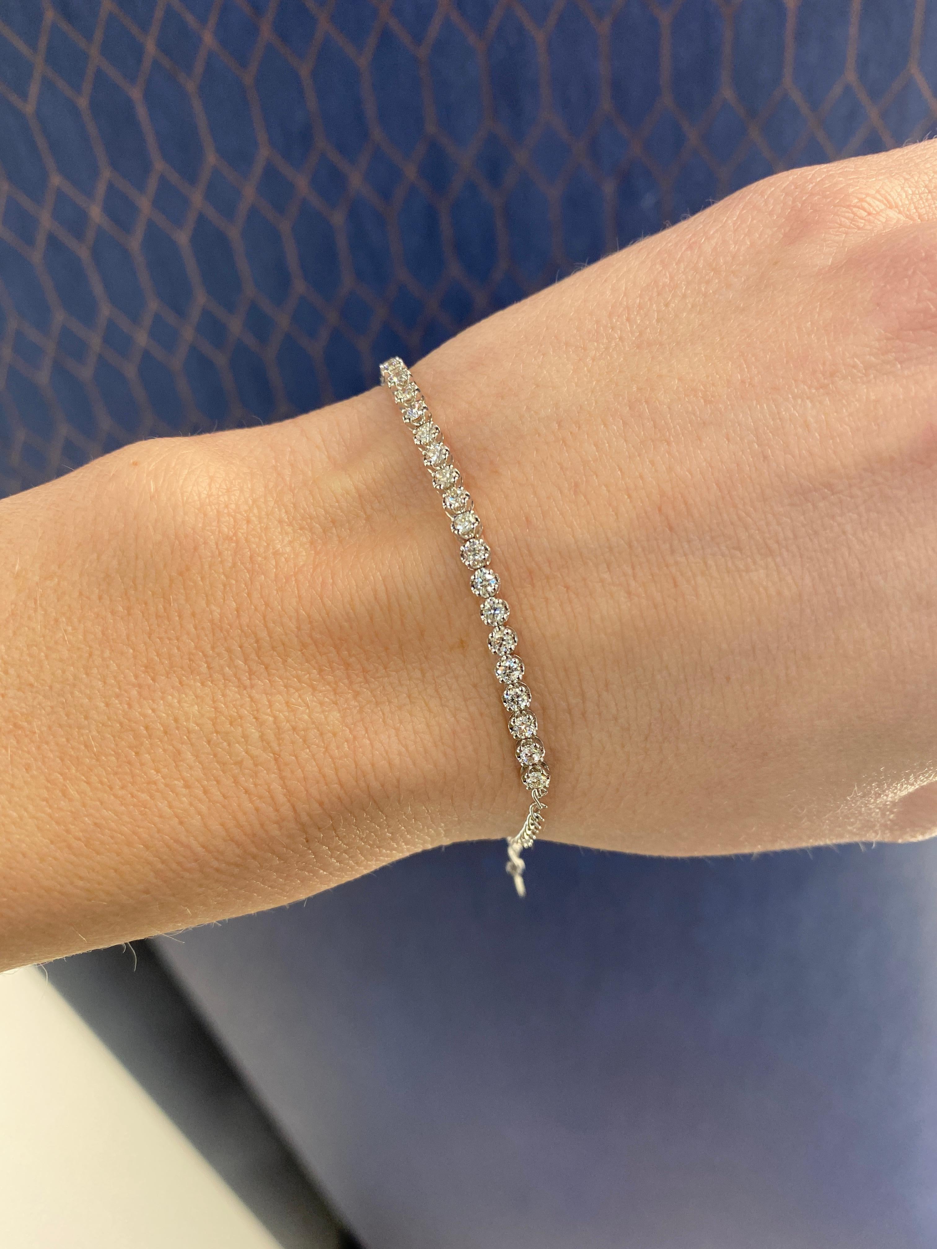 This classic tennis bracelet features 0.98 carat total weight in round diamonds that go about halfway around. It has a lobster clasp closure with heart charm. This bracelet can be worn everyday alone or layered with other bracelets. It is