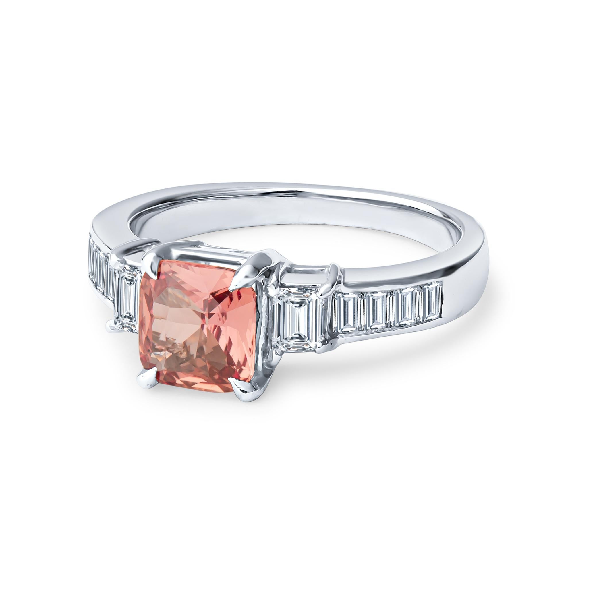 This ring features a beautiful 0.98ct, cushion cut, no heat, natural, pinkish orange Padparascha sapphire (GIA Report #5172741597) set in a platinum ring and accompanied by 0.60ctw in channel set straight baguette diamonds. The ring is a size 5, but