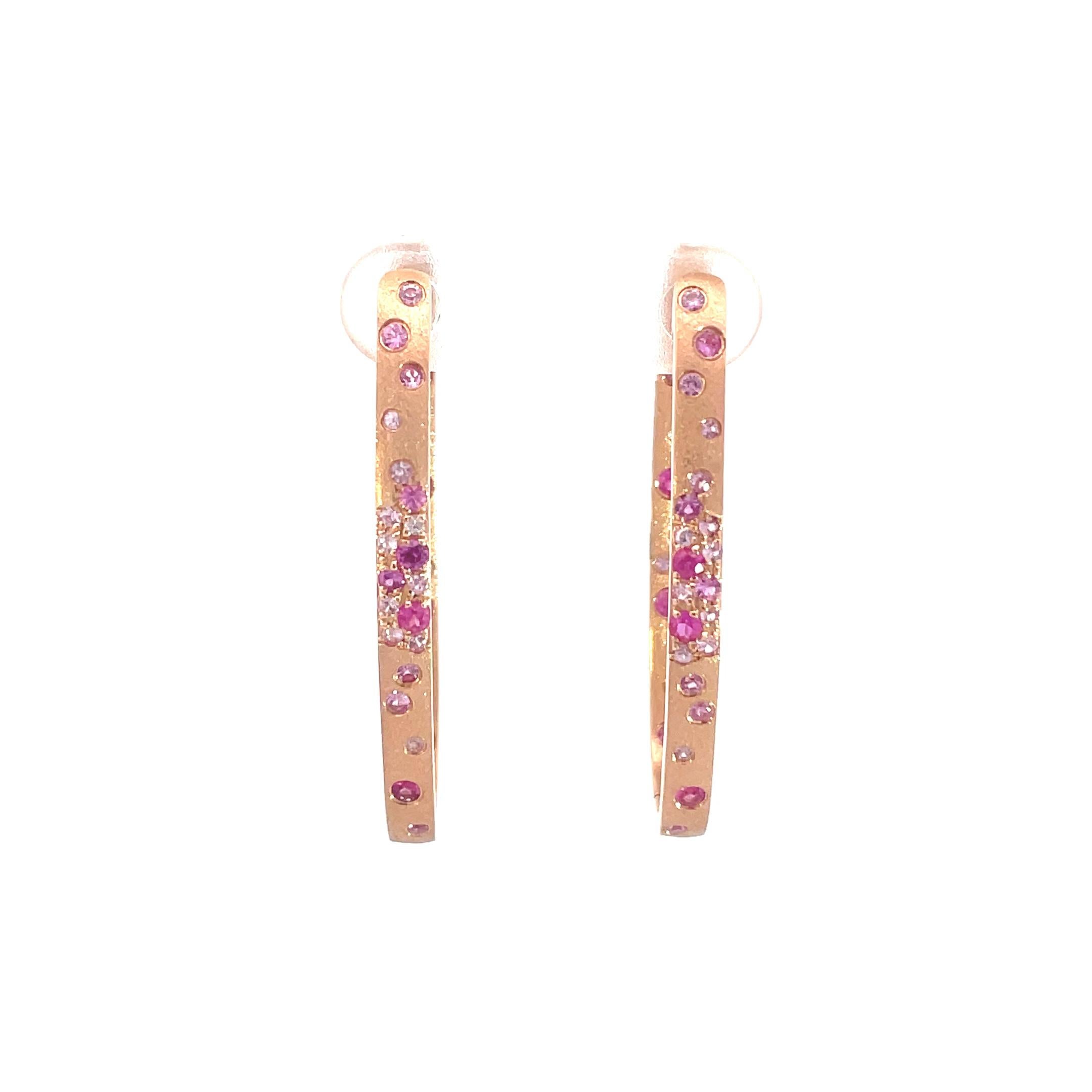 Estos pendientes de zafiro rosa y rubí son un accesorio impresionante y atemporal que puede añadir un toque de glamour y sofisticación a cualquier conjunto. Estos pendientes de aro ovalados en engaste rasante contienen 0,99 quilates de zafiros rosas