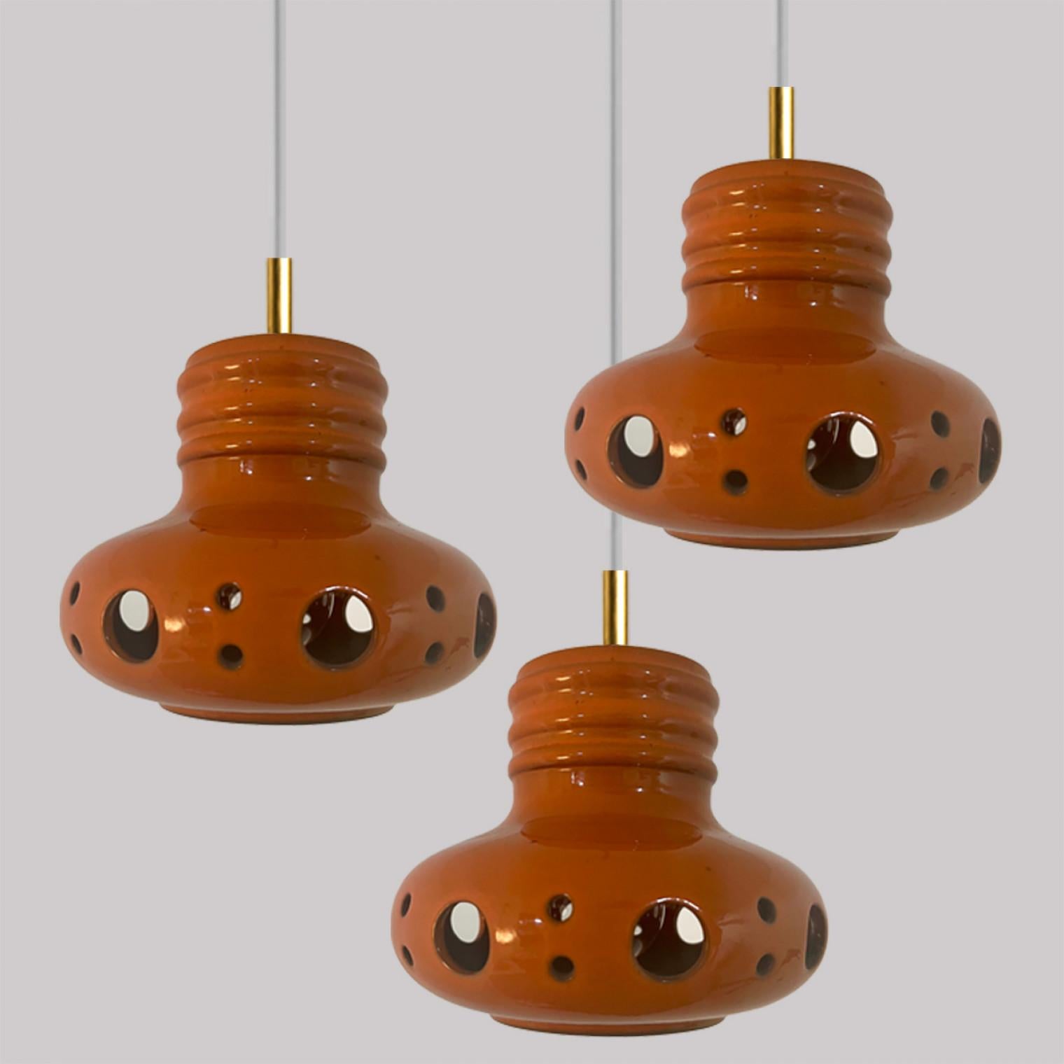 1 of the 3  spectacular and stylish ceramic pendant lights made in West-Germany around 1970's. The lights are made of orange and brown glazed ceramic and glazed in 'Fat Lava' style. The orange and brown ceramic fits beautifully with warm, gold or