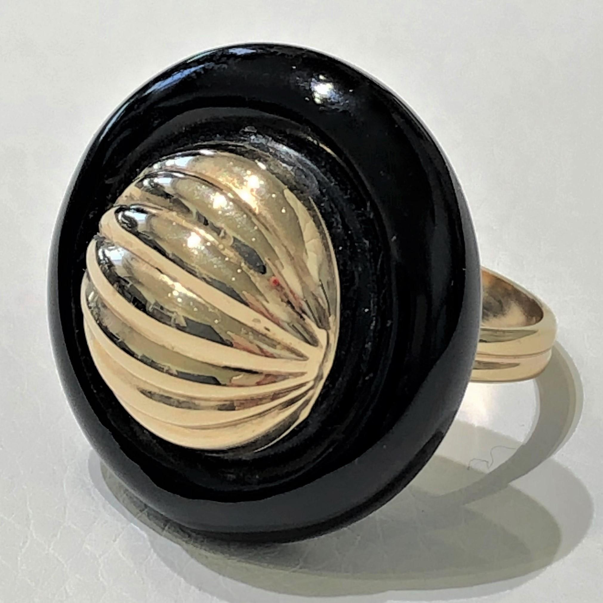 This smart, tailored, Onyx ring sports a fluted 14K gold dome center. Lightweight and comfortable to wear, it is a great every day piece. The ring is presently Size 7 and is
sizeable.  Diameter is 1 1/16 inch. Gross weight 11.3 grams.
