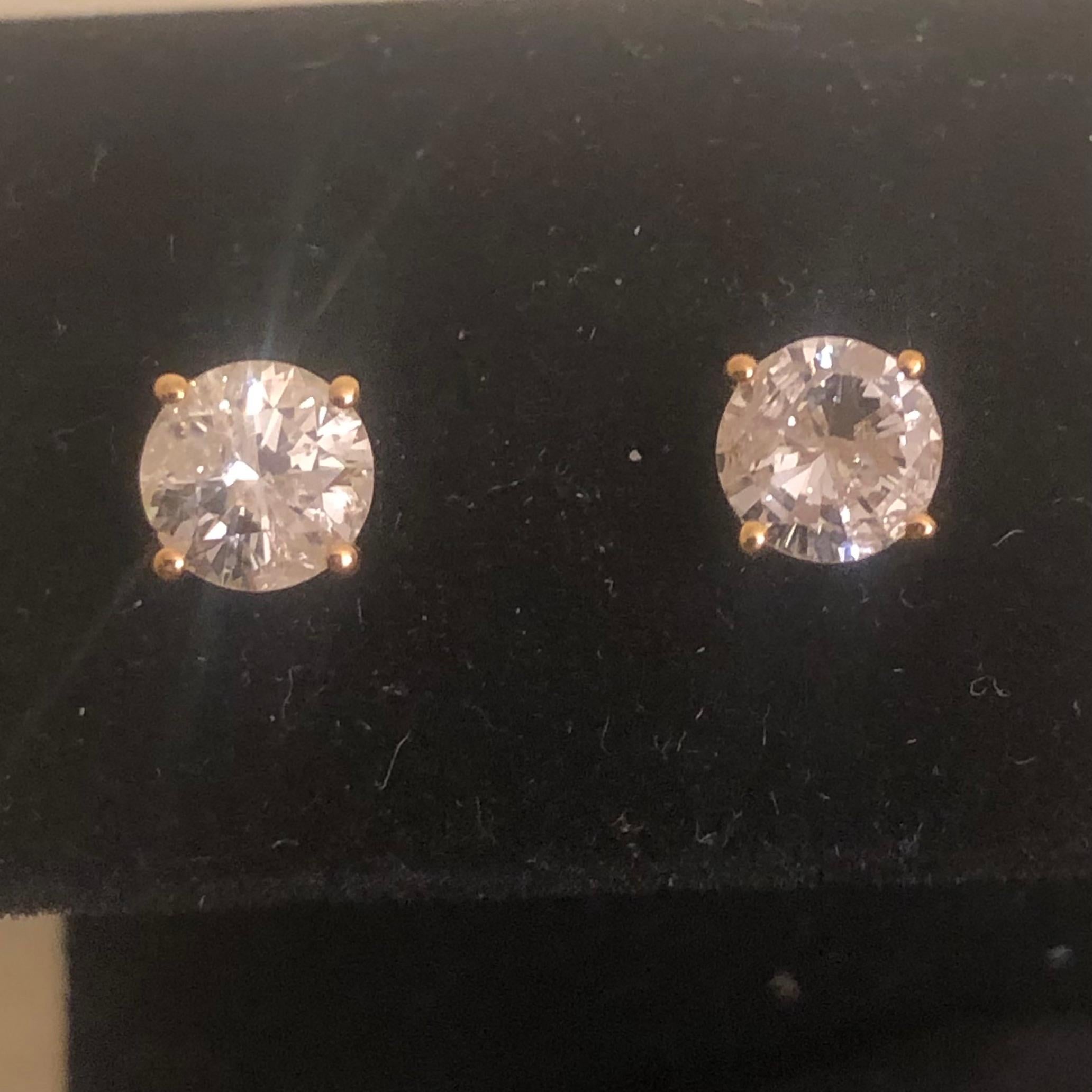 Stunning 2 Ct Round Solitaire Diamond Stud Earrings in 14K Yellow Gold. These natural diamond solitaire studs are certified with an appraisal report value of $7,470.00.

A large center solitaire diamond (size of an engagement ring) is set on each