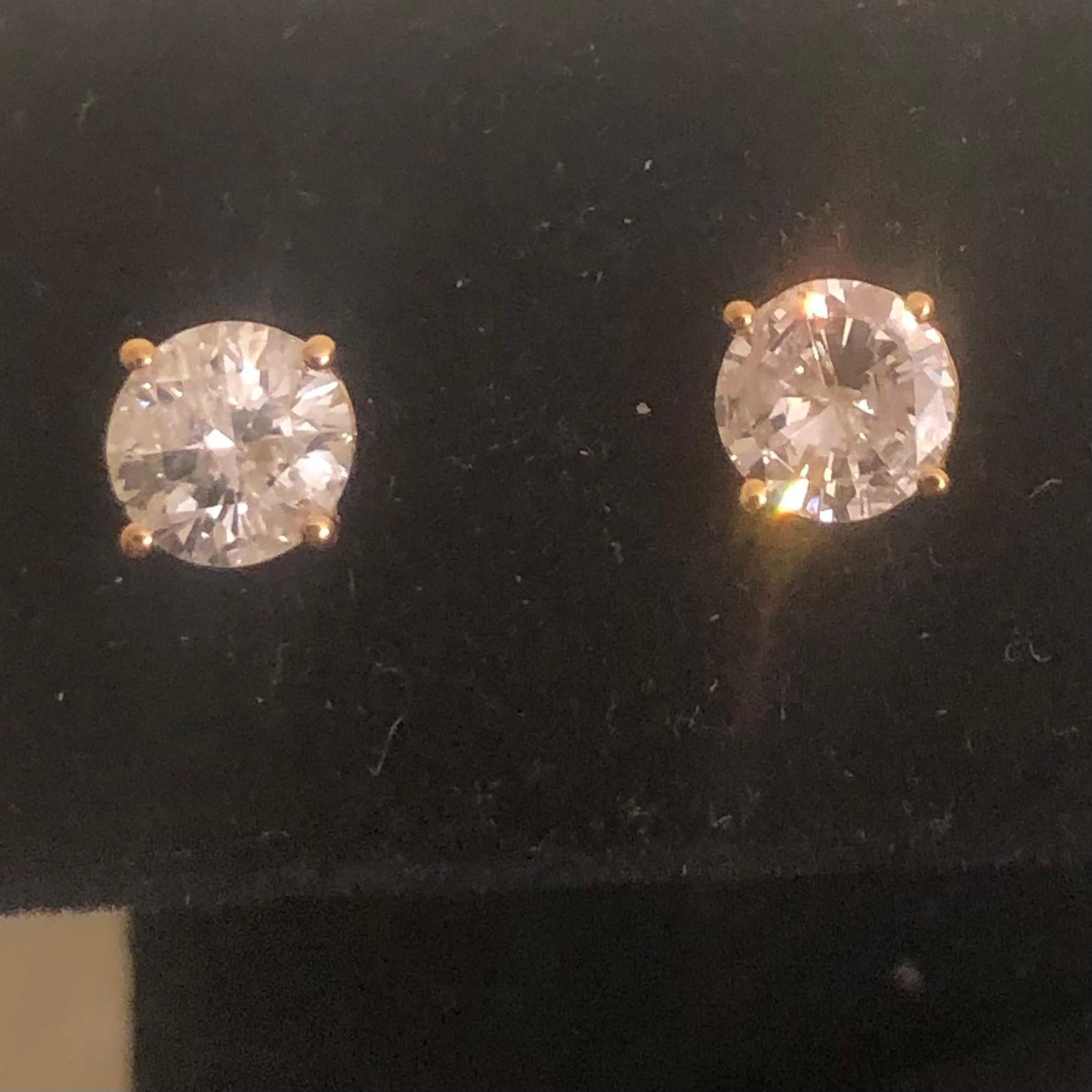 Stunning 1 1/2 Ct Round Solitaire Diamond Stud Earrings in 14K Yellow Gold. These natural diamond solitaire studs are certified with an appraisal report value of $4,470.00.

A large center solitaire diamond (size of an engagement ring) is set on
