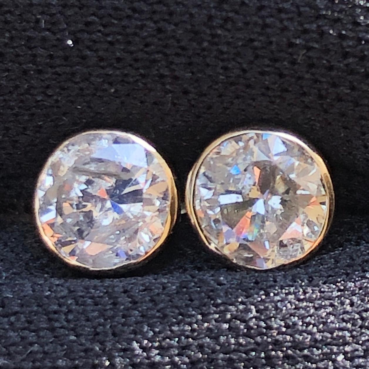 Stunning approx. 1 1/2 Ct Round Solitaire Diamond Stud Earrings Bezel Set in 14K Yellow Gold.

A large center solitaire diamond (size of an engagement ring) is set on each ear stud. A pair of approx. .76 carat each natural round solitaire diamonds,