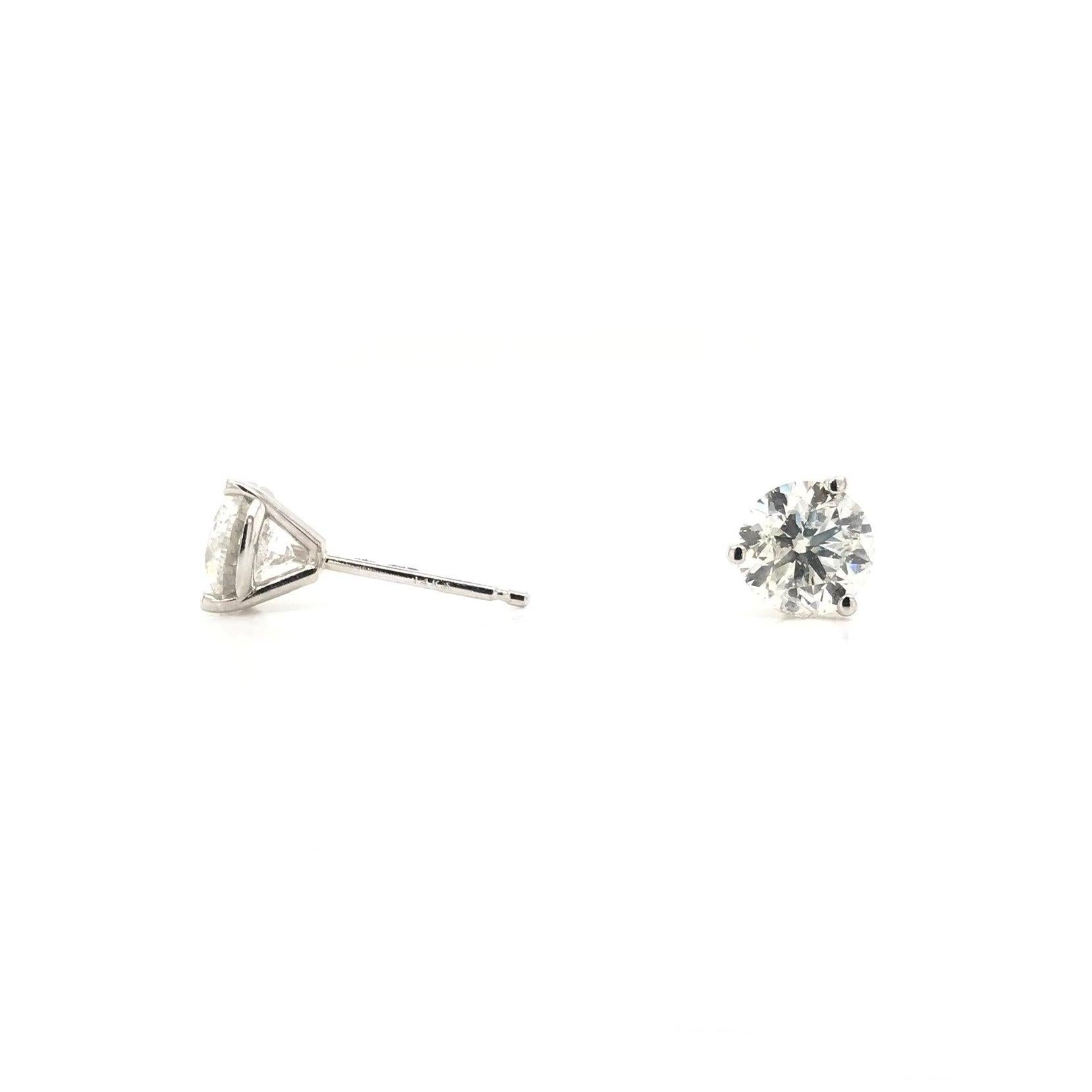 These contemporary style diamond earrings feature approximately 1.50 carats of diamonds; combined total weight. The settings are 14k white gold and are 