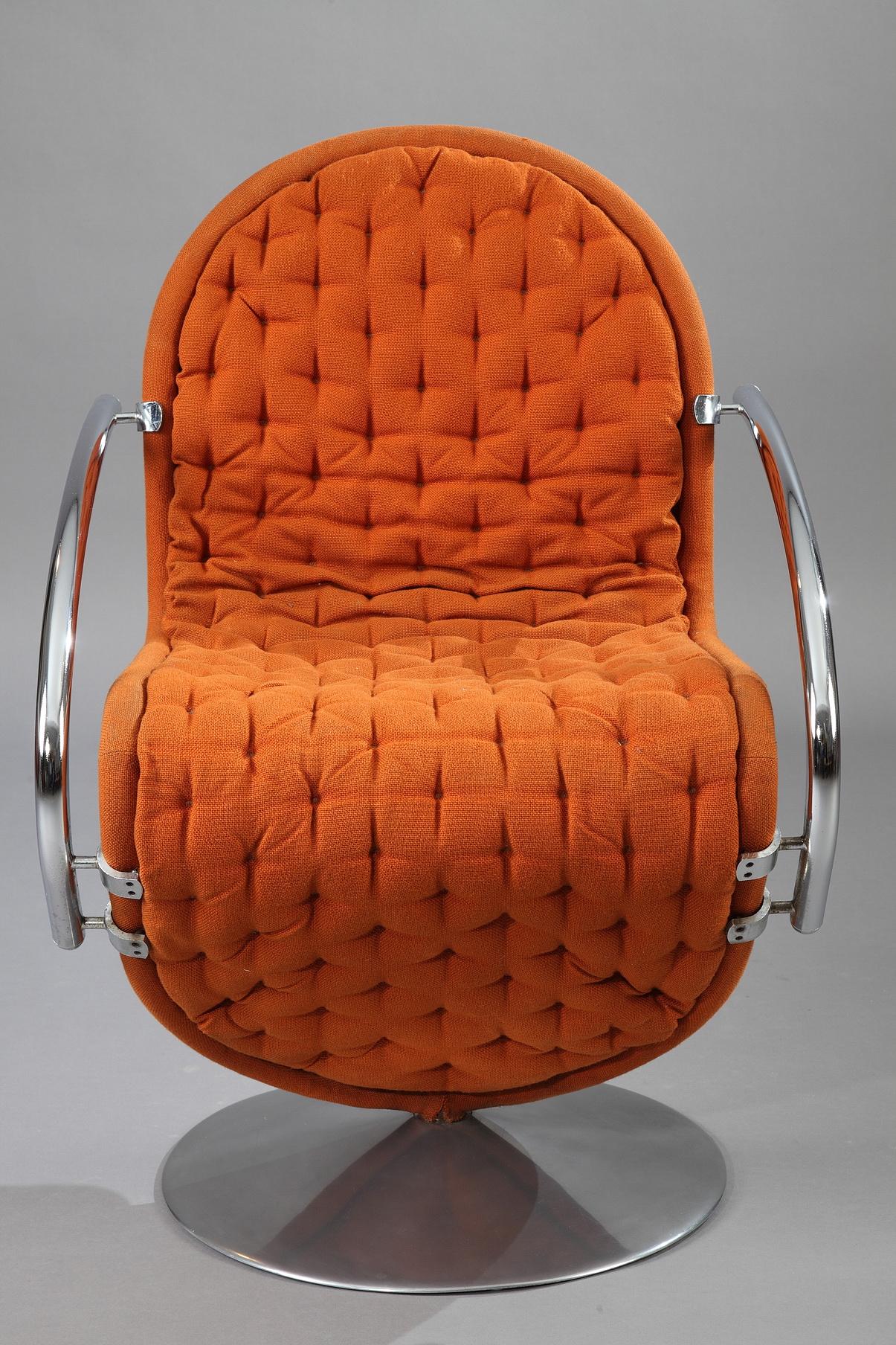 A swivel armchair from the 1-2-3 System series designed by Verner Panton. This armchair is button tufted in its original orange fabric. It rotates on a round polished aluminum base. We have 3 other chairs available. Small repair on one armchair.