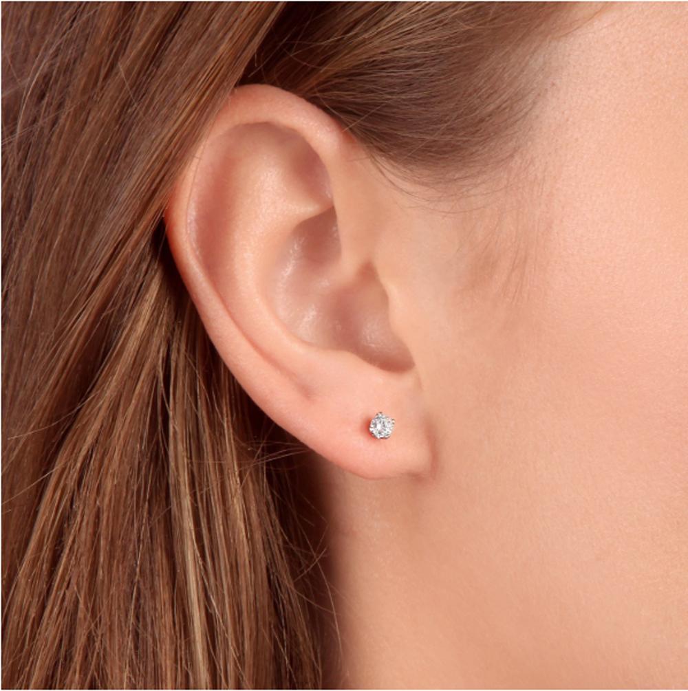This stunning matching pair of women's earrings features two round brilliant cut natural diamonds.  The diamonds are four prong set in solid 14k white gold high polished mounting with push backs.  