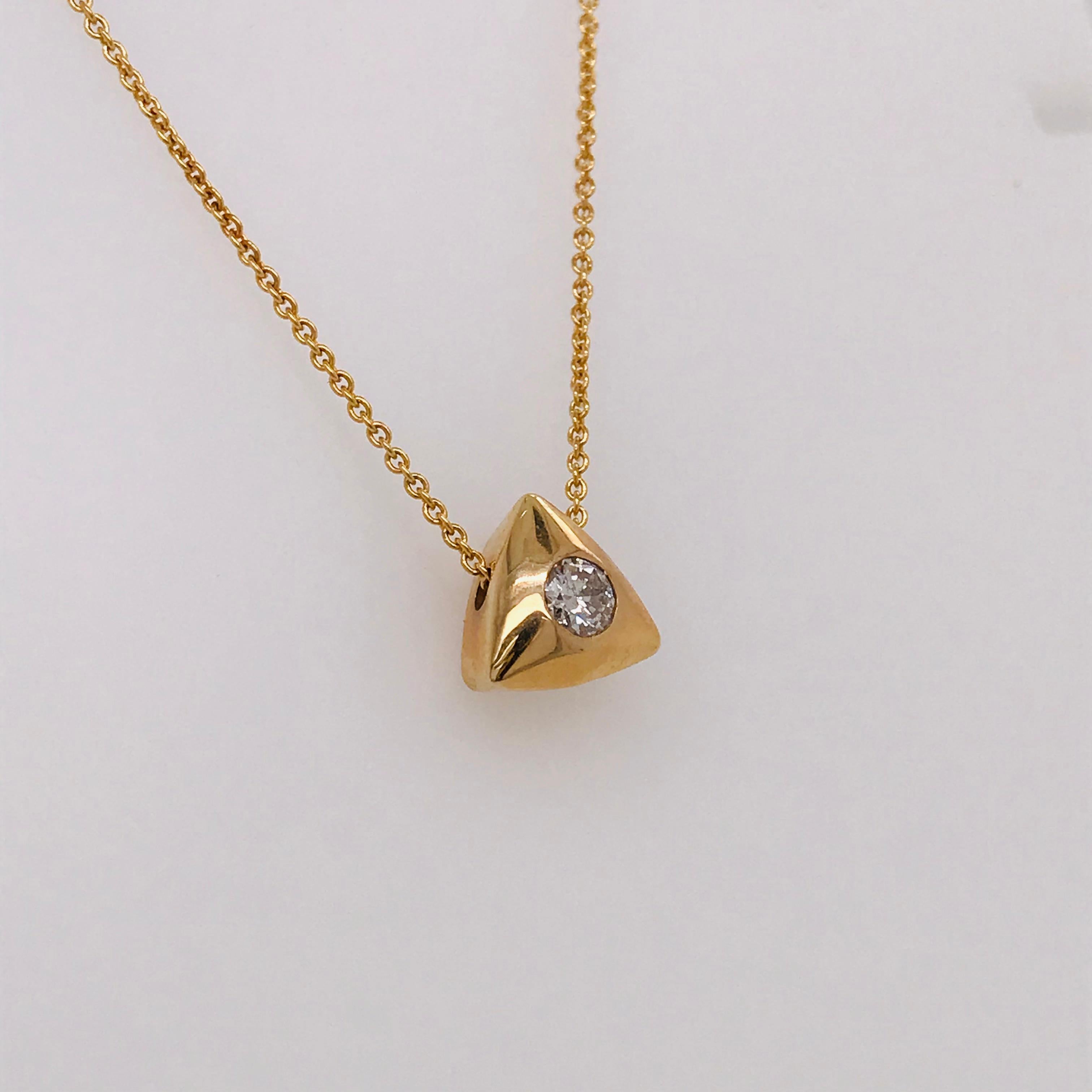 This diamond pendant has a 0.25 carat round brilliant diamond set in the center of a 14k yellow gold triangular setting. The diamond is set flush with the gold pendant. The triangular pendant is a sliding pendant that moves smoothly on the 18 inch