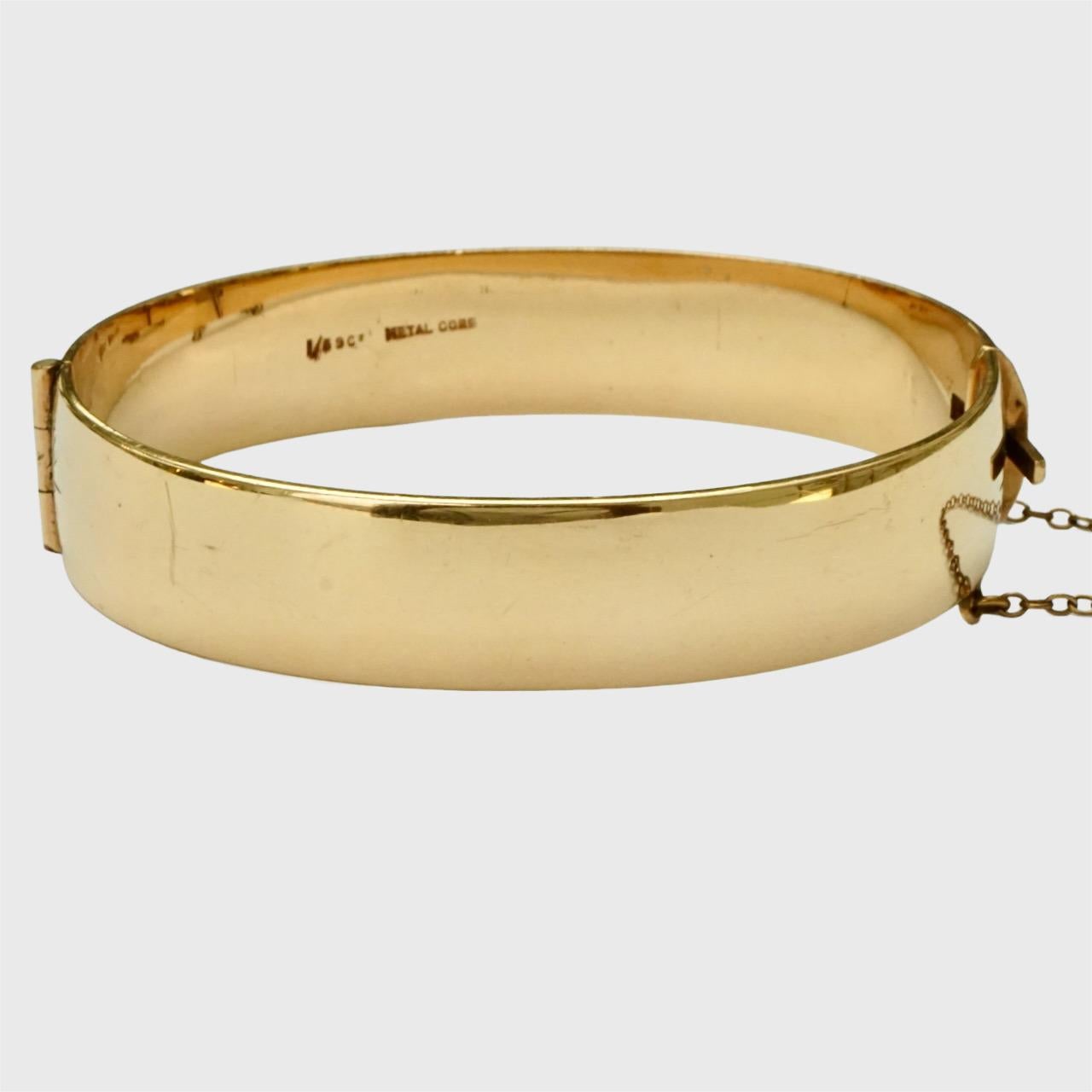 Merveilleux bracelet en or 9ct 1/5e gravé d'un tourbillon de métal, avec une chaîne de sécurité. Il s'ouvre à l'aide d'un bouton poussoir. Le bracelet présente des rayures comme prévu, le fermoir fonctionne bien.

Le bracelet est ovale, les