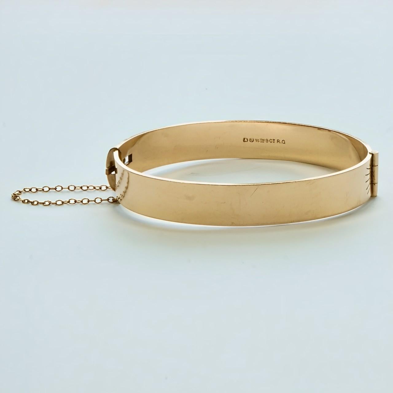
Meraviglioso bracciale bangle con incisioni a volute e foglie in oro 9ct, con catena di sicurezza. Il marchio del produttore è AJ. Il braccialetto è ovale, le misure interne sono 6 cm per 4,9 cm e la larghezza è di 1 cm. Il bracciale presenta dei
