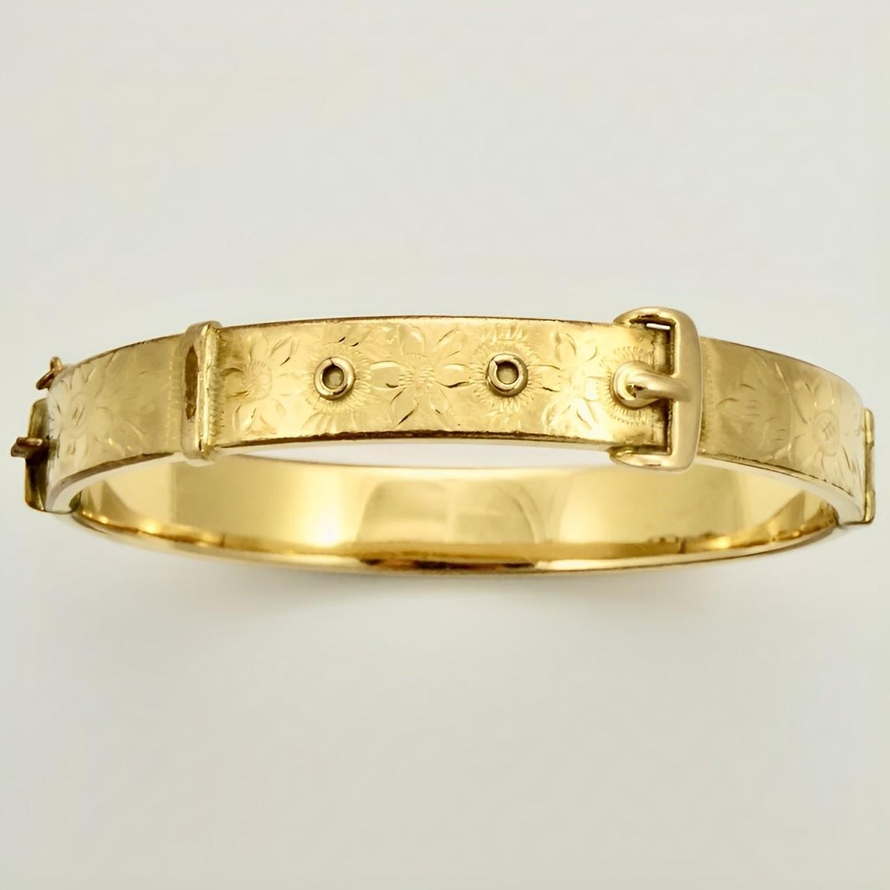 1/5th 9CT yellow rolled gold floral engraved buckle bangle bracelet, with a safety chain. It opens with a push button and the makers mark is JS. The bangle is slightly oval, the inside measurements are 6 cm / 2.3 inches by 5.4 cm / 2.1 inches, and