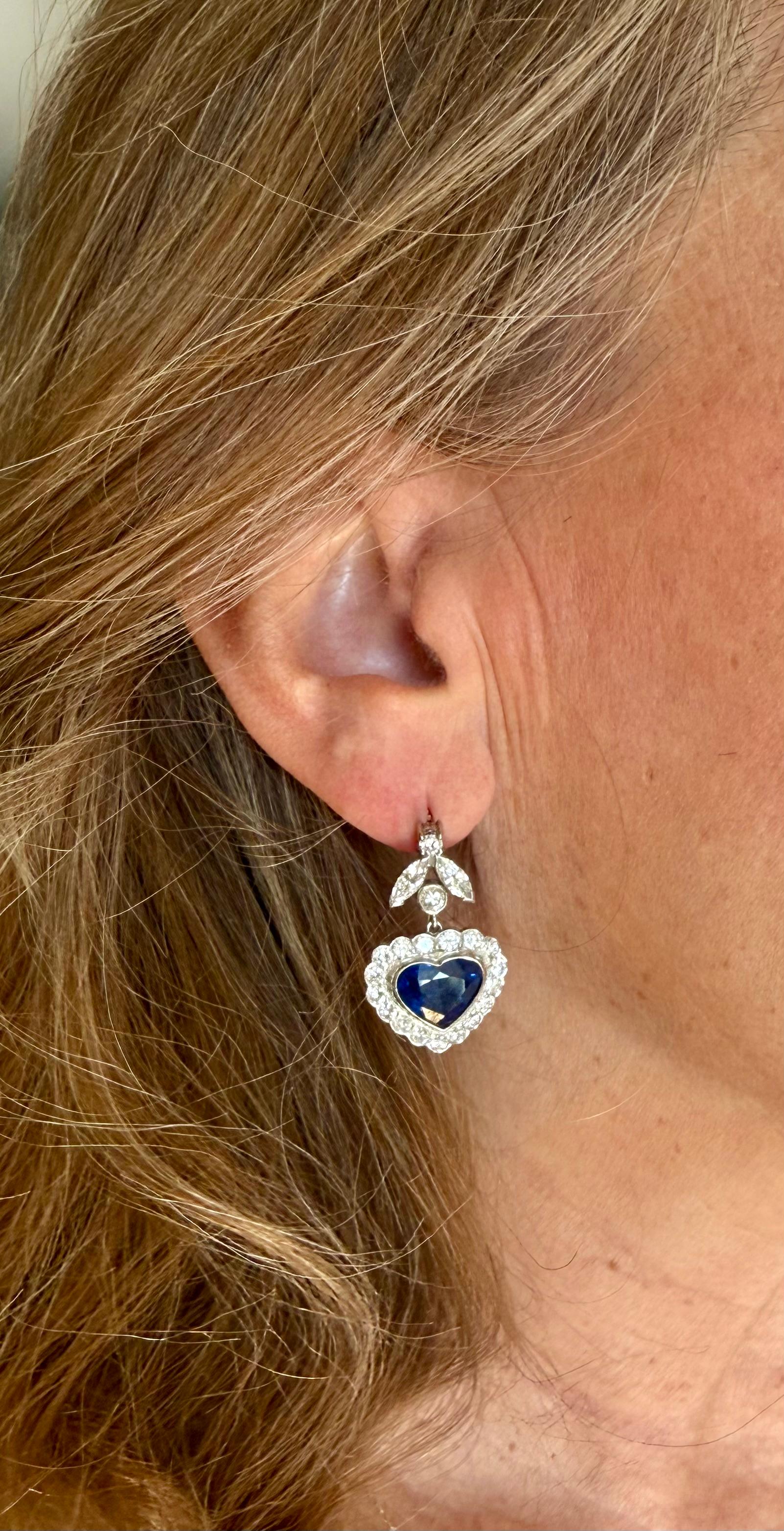 Two impressive heart-shaped Ceylon sapphires totaling approimately 7 ct  are set in these glamorous drop earrings. Displaying the vivid 